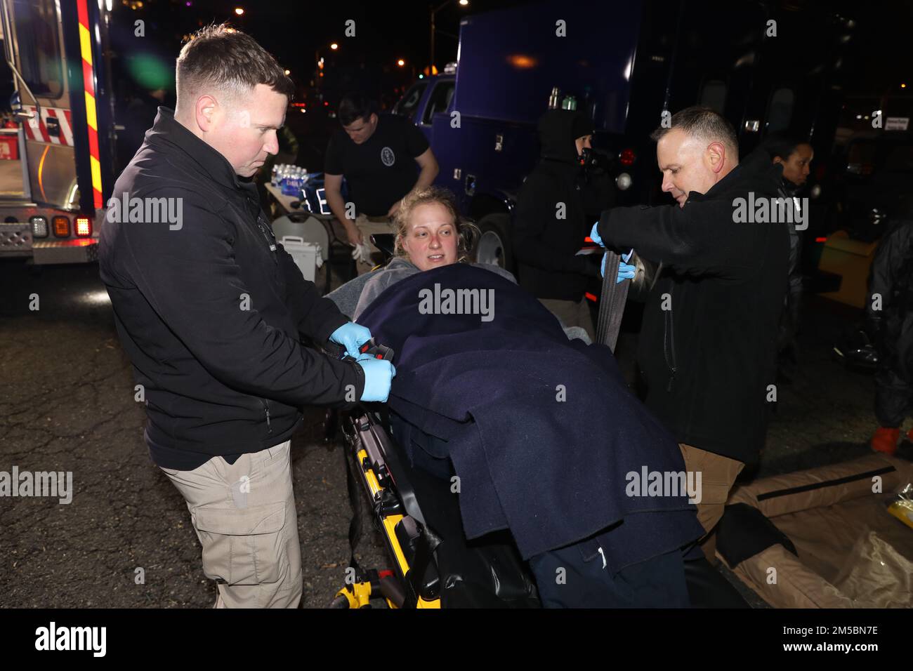 Sgt. 1. Klasse Eric Kelly, Gesundheitsspezialist, links, und Major Jason Myer, Assistenzarzt, beide Mitglieder des Maryland National Guard 32. Massenvernichtungswaffen Civil Support Teams, sichern Sgt. 1. Klasse Kim Kerschner, eine Anne Arundel County Freiwillige Feuerwehr und Mitglied derselben Einheit, Zu einer Krankentrage für den medizinischen Transport während des Verletzten-Szenarios einer pharmazeutischen Agenten-Feldübung in der Fünften Regiment-Waffenkammer in Baltimore am 23. Februar 2022. Der CST 32. nutzt diese Art von Übung, um zu Schulen, damit sie immer bereit sind, die Zivilbehörden zu unterstützen Stockfoto