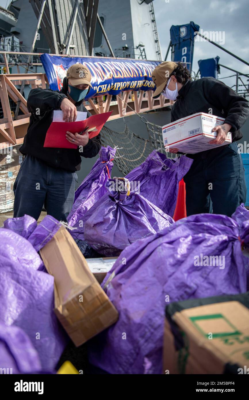 FLEET ACTIVITIES YOKOSUKA, Japan (24. Februar 2022) Logistics Specialist 2. Class Joshua Lyons, Left, aus Pangburn, Arkansas, Und Logistikspezialist 3., Klasse Alexandra Adams, aus Longview, Texas, sortiert Post am Pier, während der Arleigh-Burke-Klasse-Guided-Missile Destroyer USS Dewey (DDG 105) einen logistischen Halt bei Fleet Activities Yokosuka, Japan macht. Dewey ist der CTF 71/Destroyer Squadron (DESRON) 15, der größten nach vorn eingesetzten DESRON der Marine und der Hauptstreitkräfte der US-amerikanischen 7.-Flotte, zugeordnet. Stockfoto