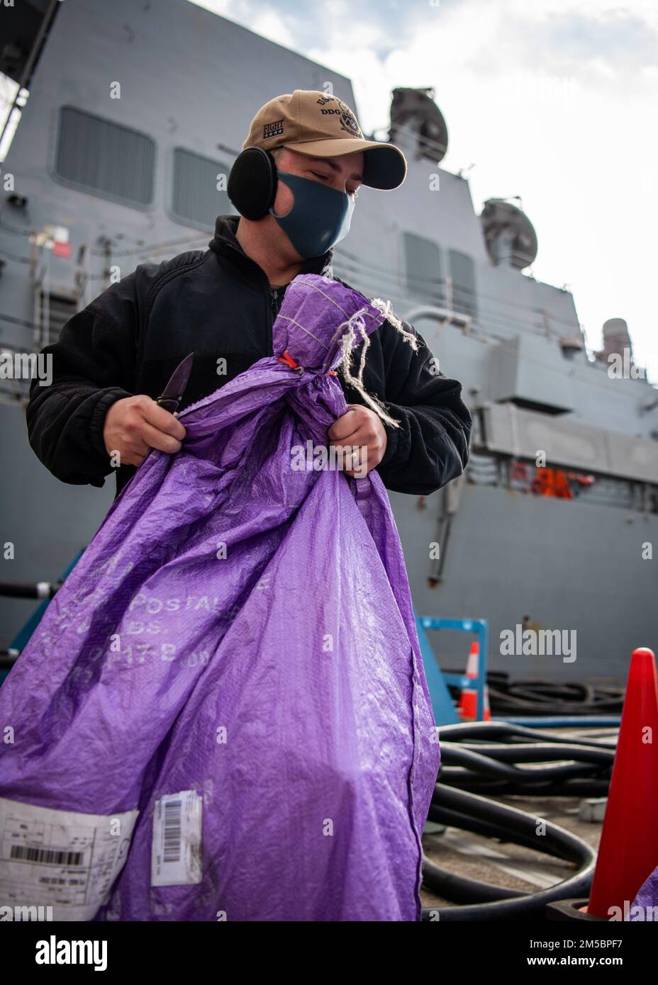 FLEET ACTIVITIES YOKOSUKA, Japan (24. Februar 2022) Logistics Specialist 2. Class Joshua Lyons aus Pangburn, Arkansas, sortiert Post am Pier, während der Arleigh Burke-Class-Guided-Missile Destroyer USS Dewey (DDG 105) einen logistischen Halt bei Fleet Activities Yokosuka, Japan, macht. Dewey ist der CTF 71/Destroyer Squadron (DESRON) 15, der größten nach vorn eingesetzten DESRON der Marine und der Hauptstreitkräfte der US-amerikanischen 7.-Flotte, zugeordnet. Stockfoto