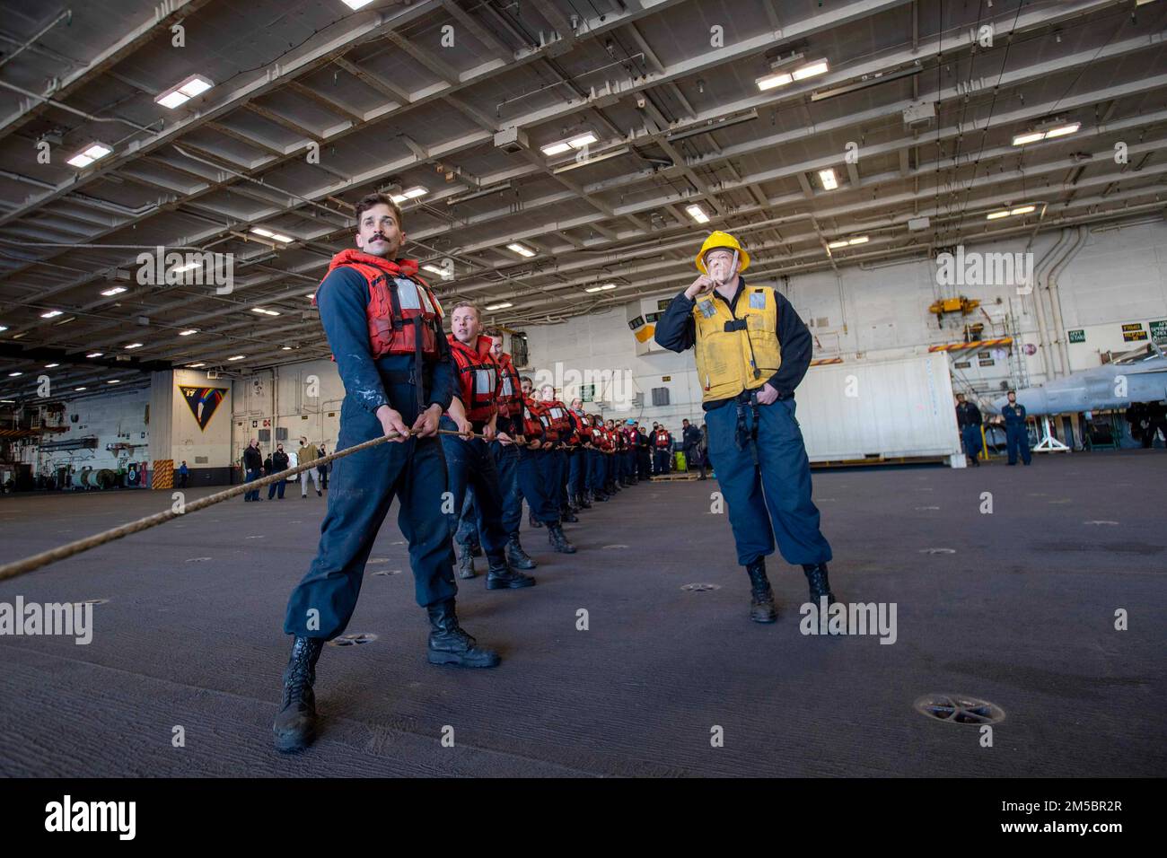 220224-N-KU796-1121 PAZIFISCHER OZEAN (24. Februar 2022) Seeleute legen während einer Wiederauffüllung auf See in der Hangarbucht an Bord des Flugzeugträgers USS Nimitz (CVN 68) eine Schlange an. Nimitz führt gerade Routineoperationen durch. Stockfoto