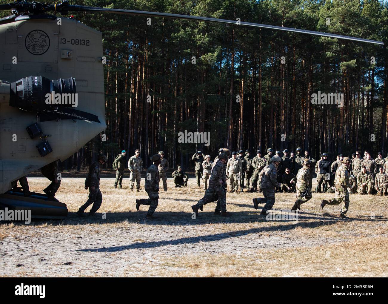 USA Fallschirmjäger vom 3. Brigaden-Kampfteam, 82. Luftwaffe demonstrieren, wie man einen CH-47 Chinook-Hubschrauber für ihre anderen Fallschirmjäger und polnischen Soldaten, die der 21. Rifle-Brigade zugeteilt wurden, ordnungsgemäß verlässt, während einer kombinierten Trainingsveranstaltung in Nowa Deba, Polen, 24. Februar 2022. Fallschirmjäger, die der 82. Luftwaffe zugeteilt wurden, befinden sich derzeit in Polen, als Teil unserer eisernen Verpflichtung gegenüber unseren polnischen Alliierten und der NATO-Allianz. Stockfoto USA Fallschirmjäger vom 3. Brigaden-Kampfteam, 82. Luftwaffe demonstrieren, wie man einen CH-47 Chinook-Hubschrauber für ihre anderen Fallschirmjäger und polnischen Soldaten, die der 21. Rifle-Brigade zugeteilt wurden, ordnungsgemäß verlässt, während einer kombinierten Trainingsveranstaltung in Nowa Deba, Polen, 24. Februar 2022. Fallschirmjäger, die der 82. Luftwaffe zugeteilt wurden, befinden sich derzeit in Polen, als Teil unserer eisernen Verpflichtung gegenüber unseren polnischen Alliierten und der NATO-Allianz. Stockfoto