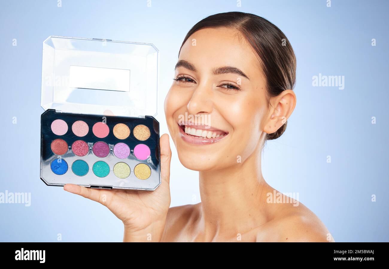 Schönheits-, Make-up- und Lidschatten-Palette mit einer Modelin im Studio auf blauem Hintergrund, um Farbe aufzubringen. Porträt, Gesicht und Kosmetik mit einem attraktiven Stockfoto