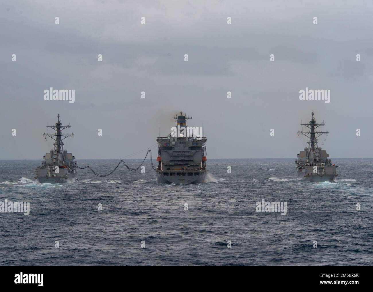 220224-N-EH998-1020 OZEAN (FEB 24,2022) die Geschoßjägerzerstörer USS Bulkeley (DDG 89), links, und die USS Delbert D. Black (DDG 119) rechts, Transit neben USNS John Lenthall (T-AO 189) während einer Auffüllung auf See während des Surface Warfare Advanced Tactical Training (SWATT). Bulkeley und Delbert D Black sind Teil von Destroyer Squadron (DESRON) 26, das die Carrier Strike Group (CSG) 10 unterstützt. SWATT wird vom Naval Surface and Mine Warfighting Development Center (SMWDC) geleitet und soll die Kampffähigkeit, Letalität und Interoperabilität der teilnehmenden Einheit verbessern Stockfoto