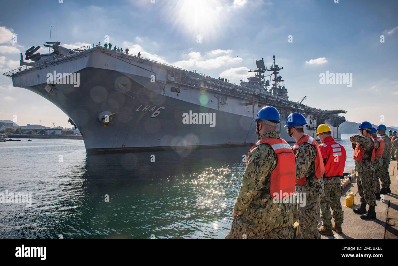 Dem Kommandeur zugeteilte Matrosen, Fleet Activities Sasebo (CFAS) bereiten sich darauf vor, beim Anlegen des Amphibienschiffs USS America (LHA 6) am 25. Februar 2022 beim CFAS zu helfen. Seit 75 Jahren stellt die CFAS Basiseinrichtungen und -Dienste bereit, wartet und betreibt diese, um die US- und alliierten Streitkräfte zu unterstützen und gleichzeitig ihre Familien und die Gemeinschaft optimal zu unterstützen. Stockfoto