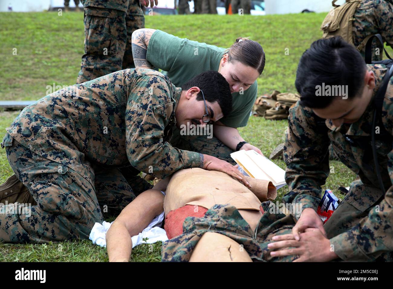 USA Navy Petty Officer First Class Elaina McMillian, rechts, Sanitäter mit 3. Medizinischem Bataillon, 3. Marine Logistics Group, trainiert Hospitalman Justin Martin, ein Sanitäter mit 9. Technisches Stützbataillon, 3D MLG, während des Corpsman Cup in Camp Foster, Okinawa, Japan, 25. Februar 2022. Der Corpsman Cup ist eine jährlich stattfindende Herausforderung, an der Marines und Matrosen teilnehmen, um Kameradschaft aufzubauen und lebensrettende Fähigkeiten zu üben. Stockfoto