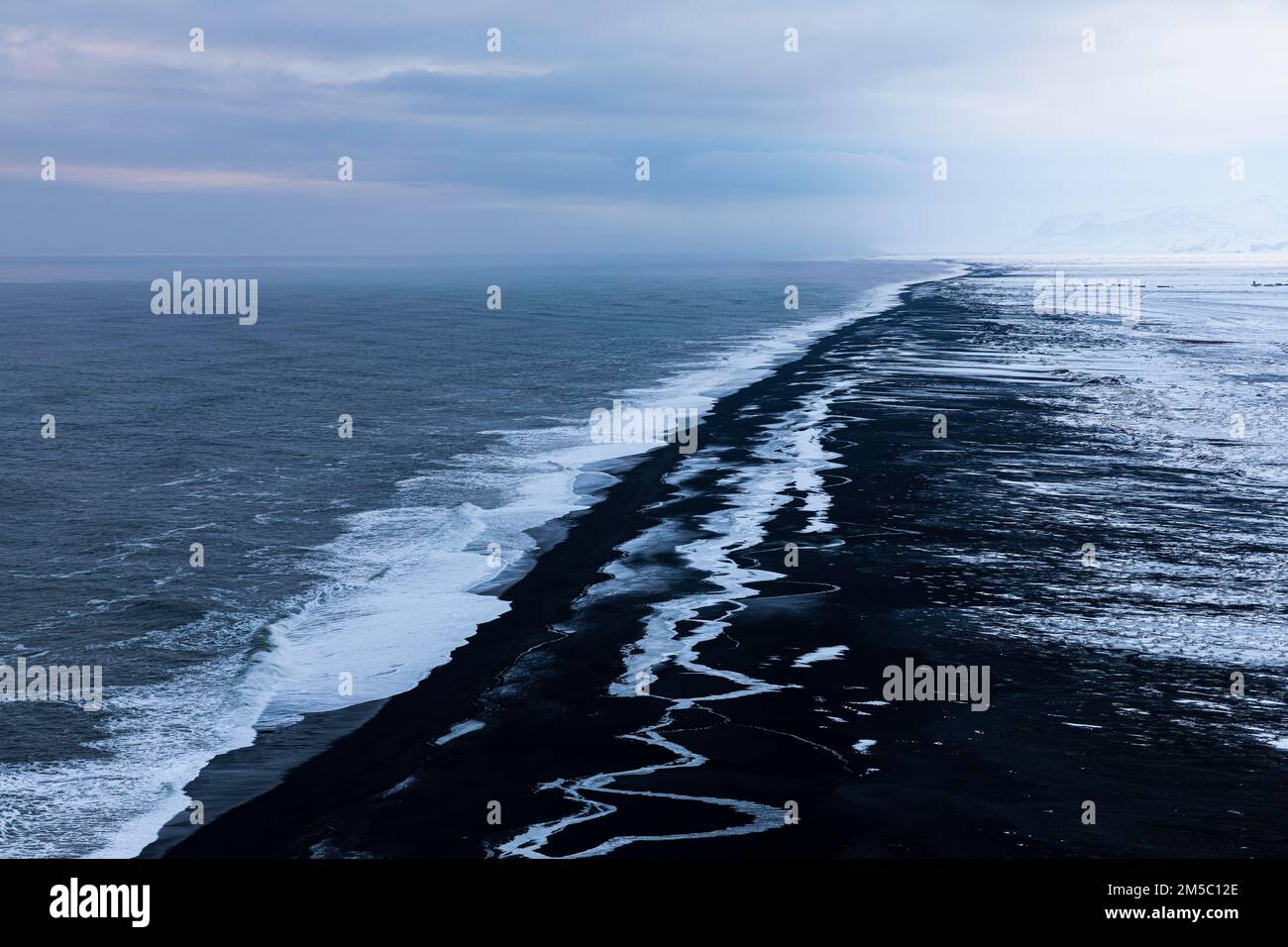 Schäumende weiße Wellen und eisige Oberflächen am schwarzen Kieselstrand Skogarsandur, in der Nähe von Dyrholaey, Sudurland, Island, Europa Stockfoto