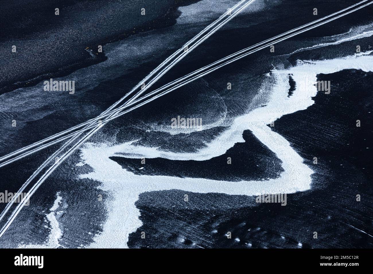 Vereiste Oberflächen und Fahrzeugspuren am schwarzen Kieselstrand von Skogarsandur, in der Nähe von Dyrholaey, Sudurland, Island Stockfoto