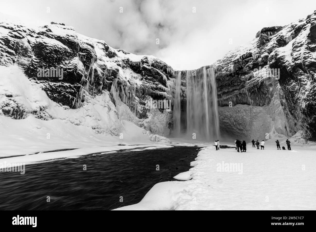 Skogafoss Wasserfall mit eisigem und verschneitem Felsgesicht, Schwarz-Weiß-Foto, Sudurland, Island, Europa Stockfoto