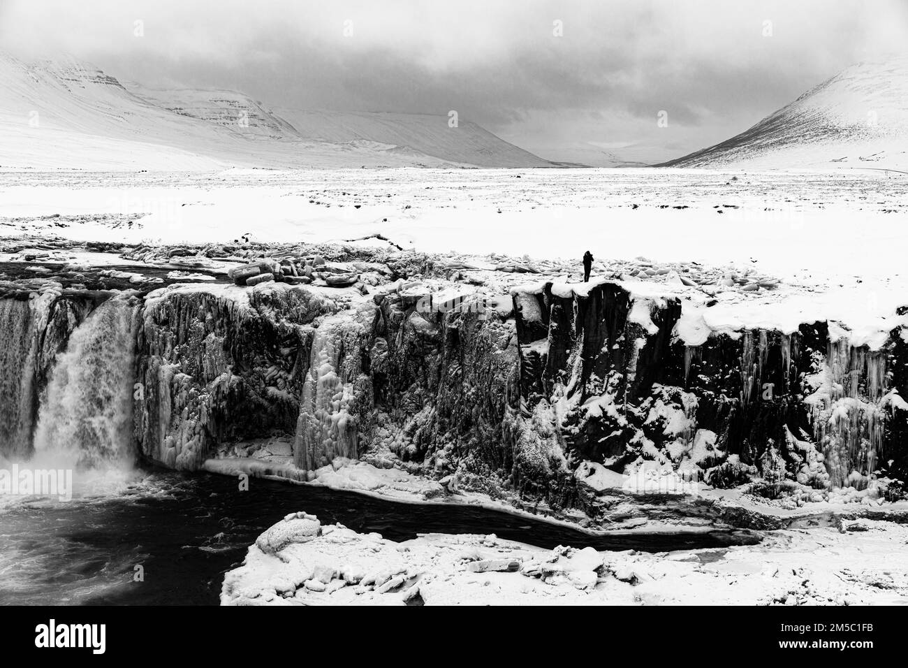 Eisbedeckte und schneebedeckte Felswand am Godafoss Wasserfall, verschneite Landschaft, Schwarzweißfotos, Eyestra in Nordisland, Island Stockfoto