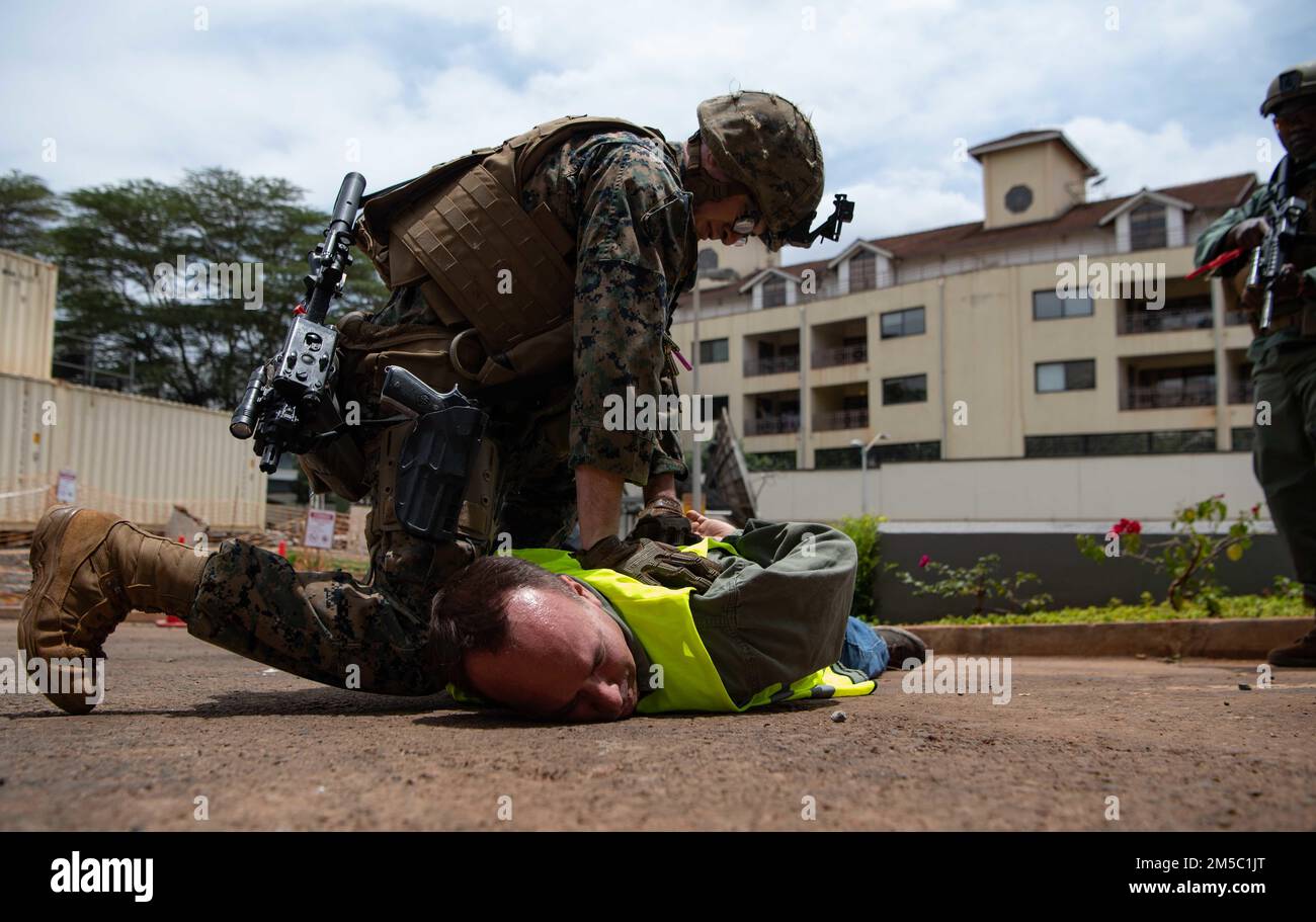 Mitglied der Marine Security Augmentation Unit (MSAU) mit Sitz außerhalb der USA Botschaft Nairobi, Kenia, hält einen simulierten Demonstranten während einer Emergency Deployment Readiness Exercise (EDRE) in Nairobi, Kenia, am 25. Februar 2022 fest. Die MSAU ist ein Kommando innerhalb der Marine Corps Embassy Security Group und bietet dem Marine Corps die Möglichkeit, kleine, aufgabenorganisierte Einheiten zur Unterstützung der USA einzusetzen Außenministerium. Stockfoto