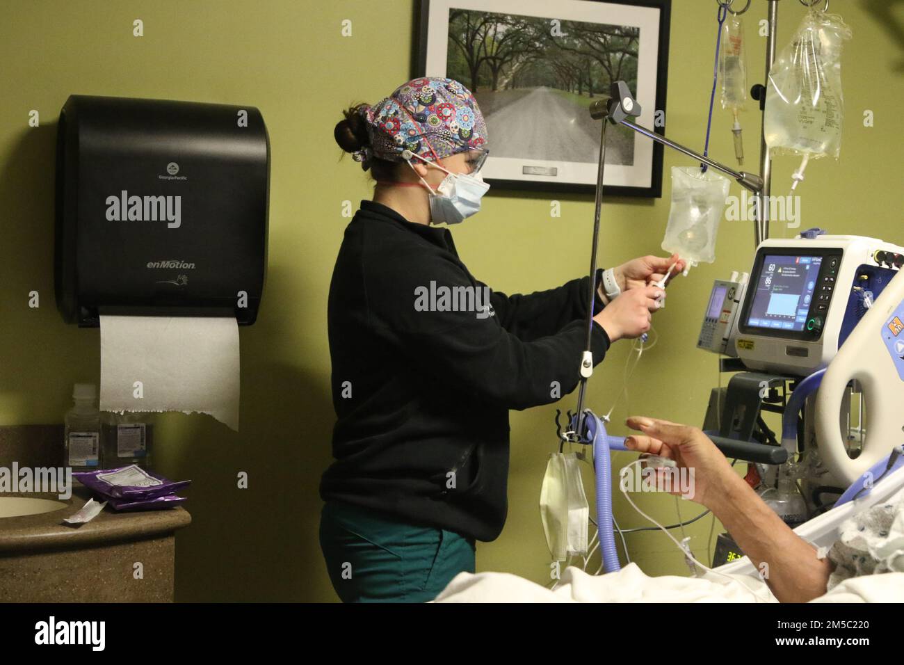 BUFFALO, NEW YORK. - AUS DEN USA Navy Fähnrich Kelly Banko, eine Krankenschwester, die einem militärischen medizinischen Team zugewiesen ist, gibt einem Patienten Flüssigkeit und unterstützt gleichzeitig die COVID-Response-Operationen am Erie County Medical Center in Buffalo, New York, 25. Februar 2022. Nördliches Kommando, durch die USA Army North ist nach wie vor entschlossen, das Verteidigungsministerium flexibel bei der COVID-Reaktion der gesamten Regierung zu unterstützen. Stockfoto