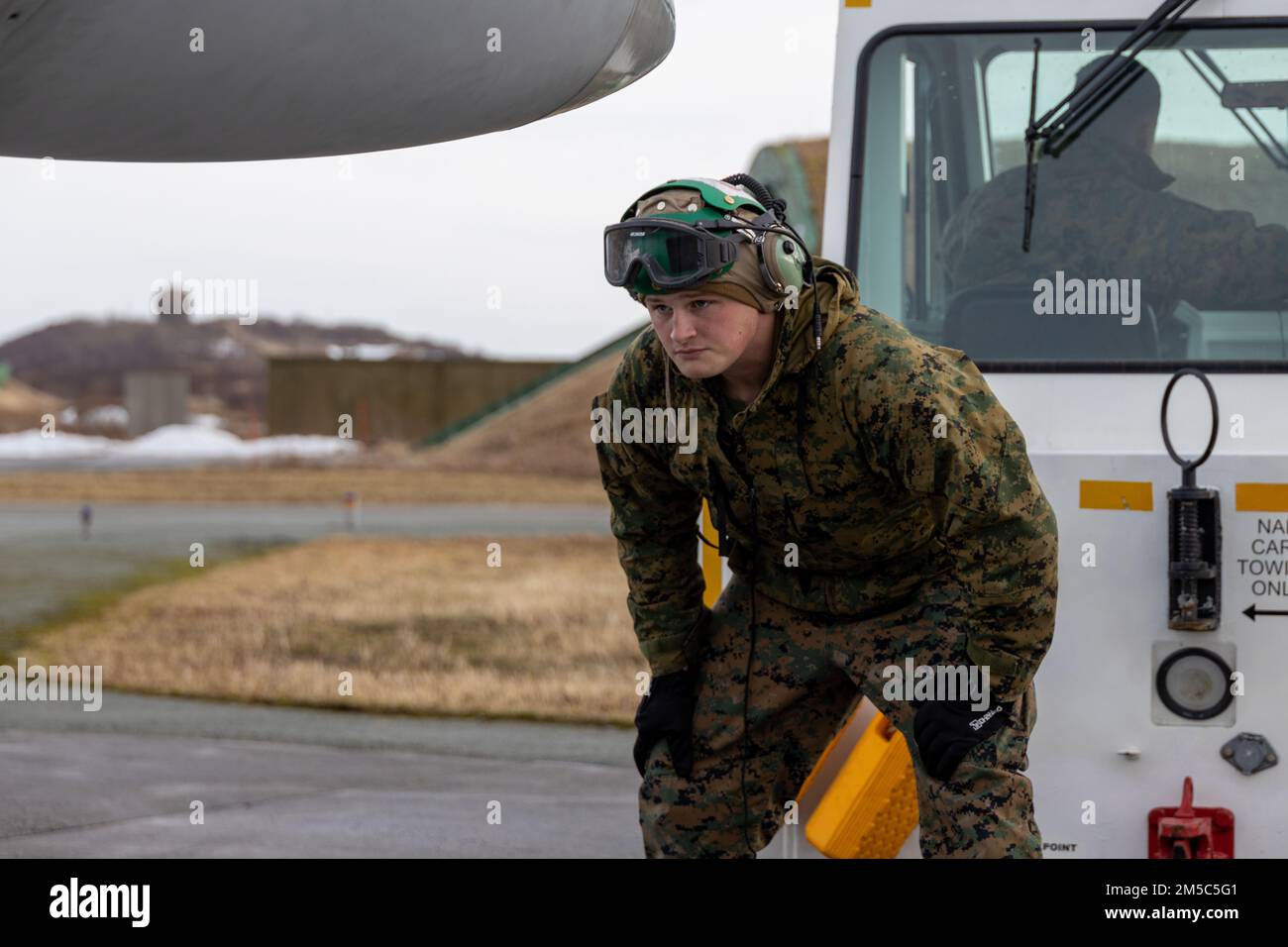 USA Landon Amos, ein Mechaniker für Starrflügelflugzeuge mit Angriffsgeschwader der Marine Fighter 312, 2. Marine Aircraft Wing, hilft beim Abschleppen einer F/A-18 Hornet am Luftwaffenstützpunkt Bodø, Norwegen, 28. Februar 2022. Übung Cold Response '22 ist eine alle zwei Jahre stattfindende norwegische nationale Bereitschafts- und Verteidigungsübung, die in ganz Norwegen stattfindet, unter Beteiligung jedes seiner Militärdienste sowie von 26 weiteren alliierten Nationen und regionalen Partnern der Nordatlantikvertrags-Organisation (NATO). Stockfoto