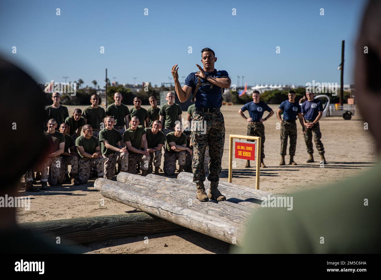 USA Marinekorps Staff Sgt. Jonathan Fuentes, Senior Drill Instructor bei Mike Company, 3. Recruit Training Battalion, unterrichtet Rekruten über die richtigen Techniken für Holzbohrer im Marine Corps Recruit Depot San Diego, 28. Februar 2022. Die Rekruten haben vor der Durchführung der Übungen eine Demonstration der richtigen Hebetechniken beobachtet. Stockfoto