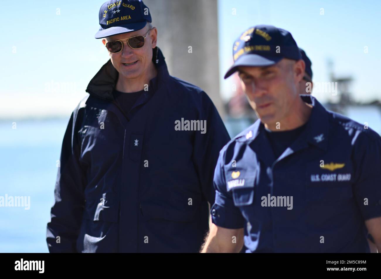 Stellvertretender Befehlshaber der Pazifikregion Peter Gautier und Captain Timothy Barelli, Befehlshaber der USA Coast Guard Sector San Diego, gehen Sie gemeinsam auf dem Pier von Sector San Diego während der Führung des Admirals über den Stützpunkt, 28. Februar 2022. Der Zweck des Besuchs ist es, Partnerschaften hervorzuheben und sicherzustellen, dass die Einheiten der Küstenwache in San Diego einen soliden Plan für die Zukunft haben. Stockfoto