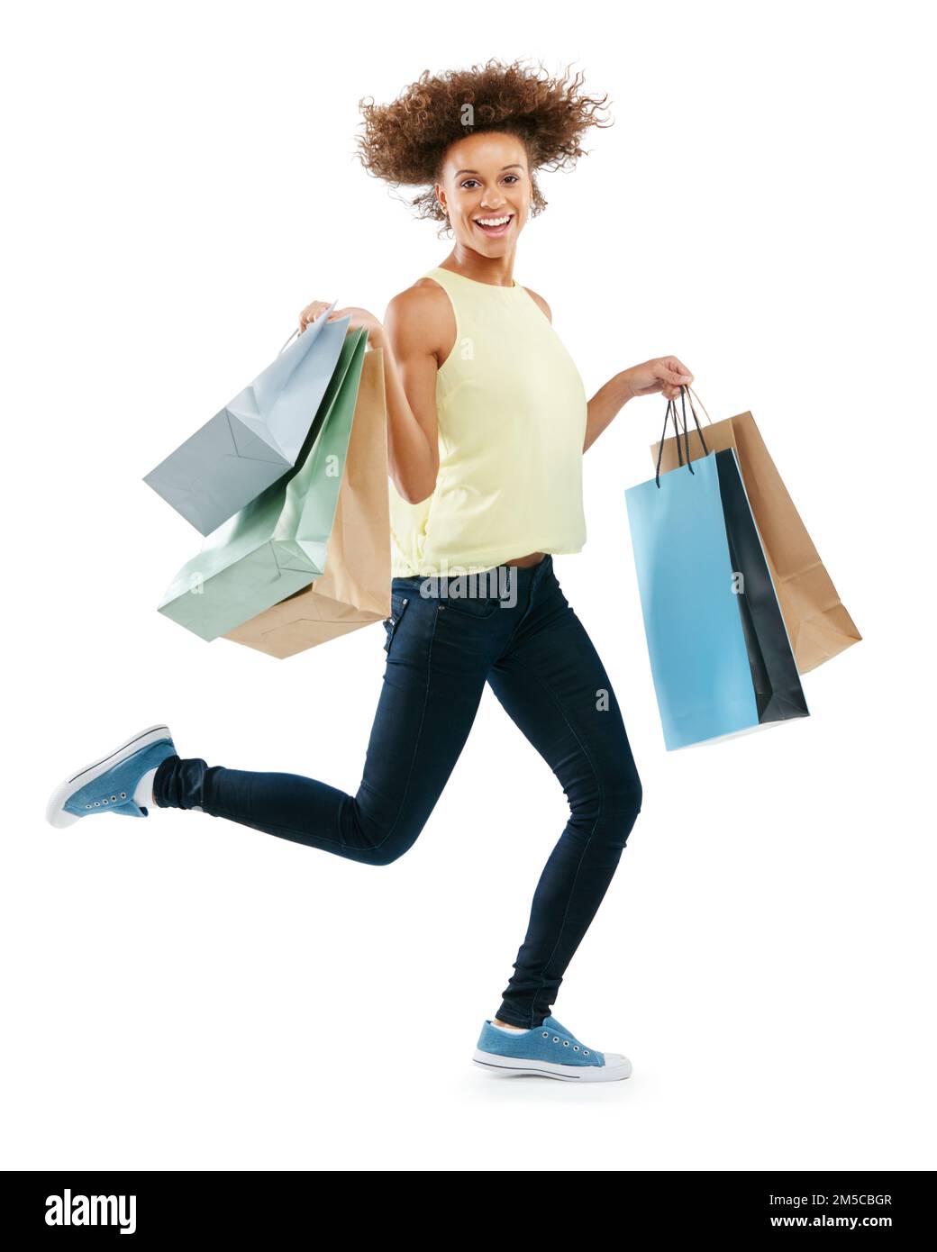 Du wirst nicht glauben, wie viele Schnäppchen ich gefunden habe. Studio-Porträt einer aufgeregten jungen Frau, die Einkaufstüten trug und vor Freude gegen einen Weißen sprang Stockfoto