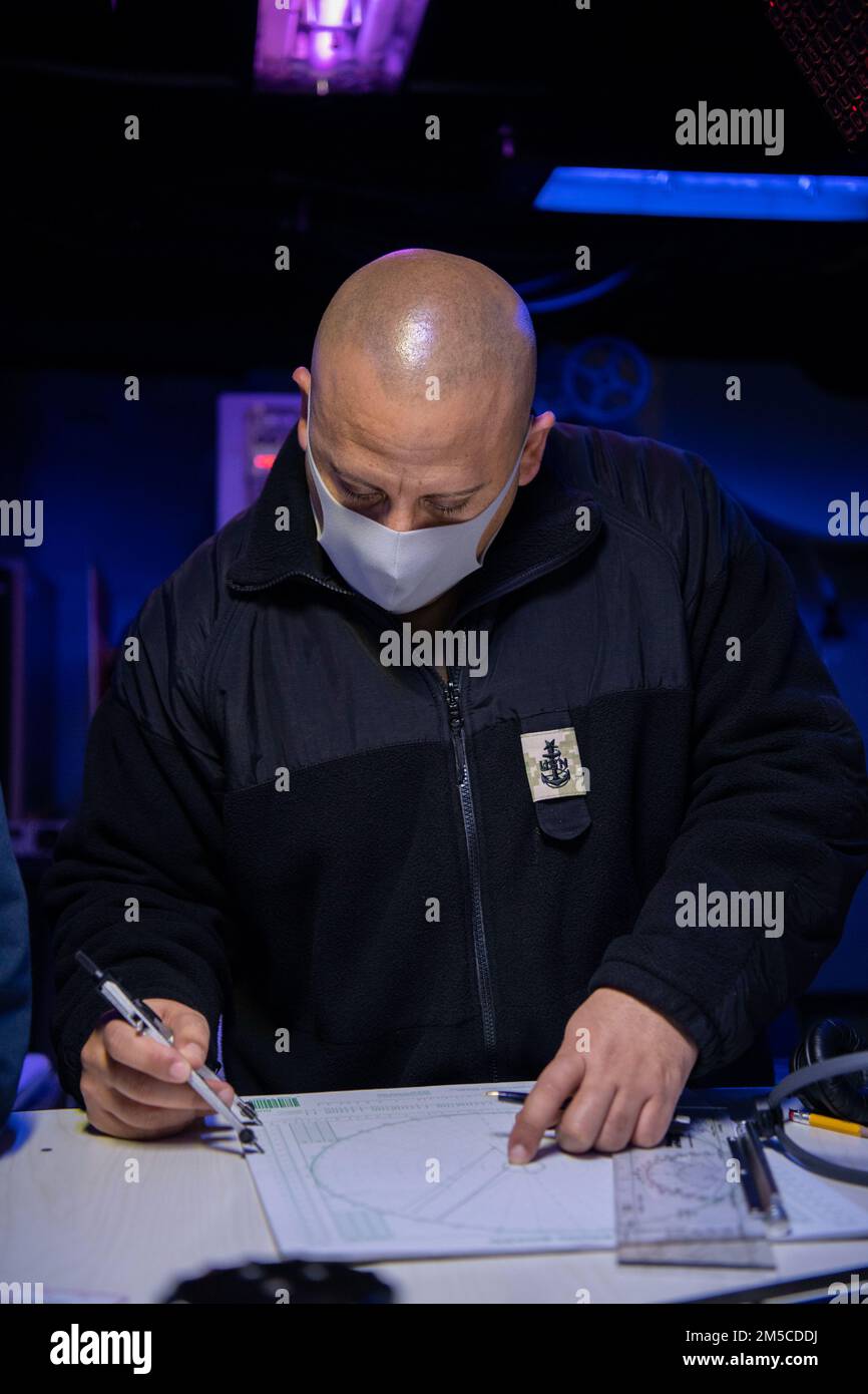 PACIFIC OCEAN (1. März 2022) Senior Chief Operations Specialist Geraldo Anzaldo aus Anaheim, Kalifornien, plant Manövriertafellösungen im Combat Information Center an Bord der Arleigh-Burke-Klasse-Guided-Missile Destroyer USS Dewey (DDG 105) und nimmt an der bilateralen Advanced Warfare Training (BAWT) Teil. BAWT ist eine jährliche bilaterale Schulungsübung, die die Partnerschaft zwischen den US-Streitkräften und den japanischen Streitkräften verbessert. Im Mittelpunkt der diesjährigen Übung stand die Verbesserung der Bereitschaft und Interoperabilität der Koalitionstruppen der US-amerikanischen und japanischen Seeschifffahrts-Selbstverteidigungskräfte. Stockfoto