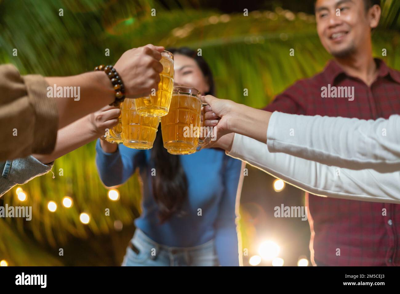 Eine Gruppe glücklicher Freunde trinkt und toastet Bier in einem Partygarten Stockfoto