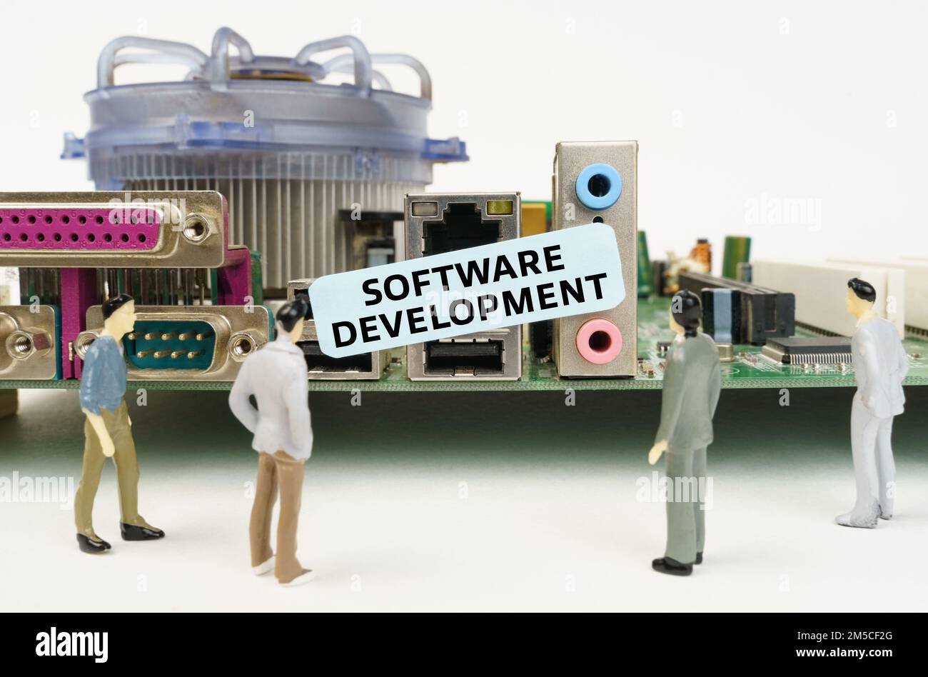 Technik und Computerkonzept. Figuren von Menschen stehen neben dem Motherboard und schauen auf den Aufkleber mit der Inschrift: Software Develo Stockfoto