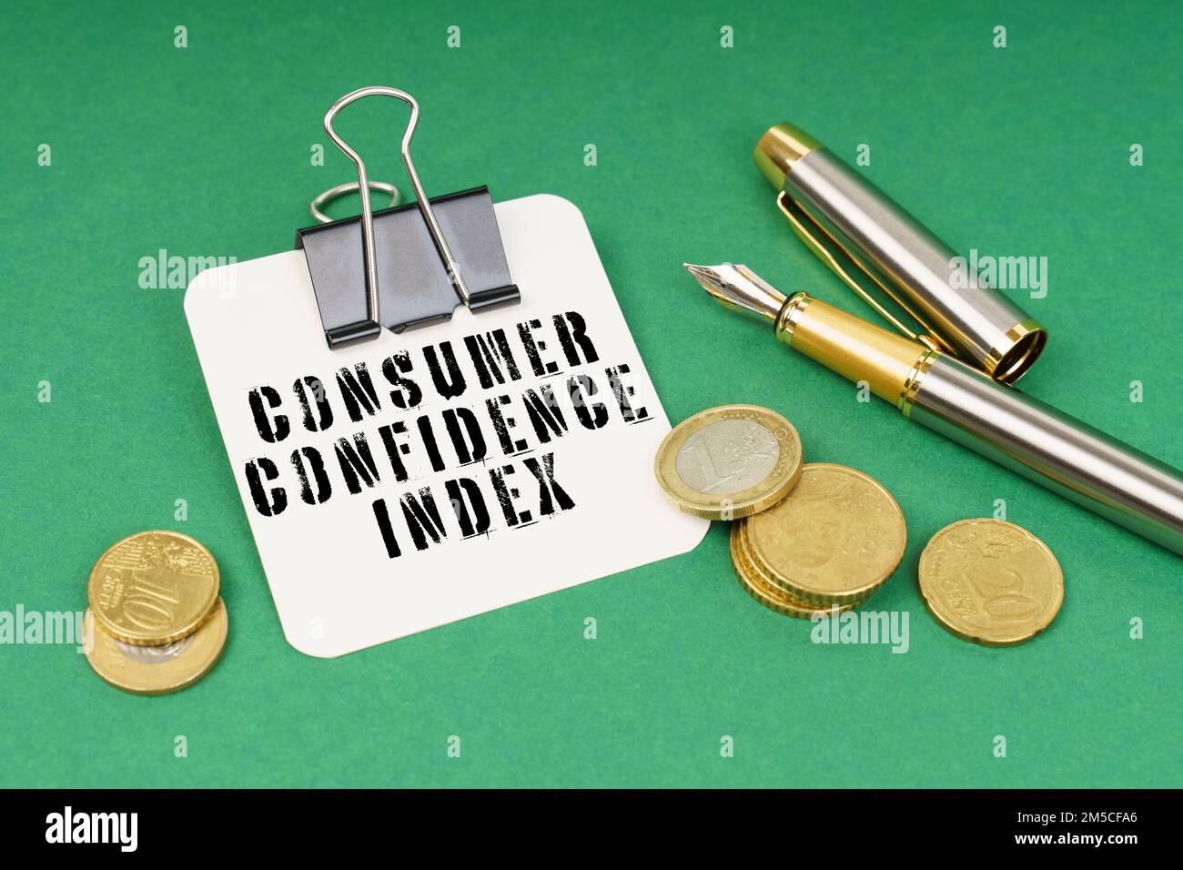 Geschäfts- und Finanzkonzept. Auf einer grünen Oberfläche, einem Stift, Münzen und einem Notizblock mit der Aufschrift - Verbrauchervertrauensindex Stockfoto