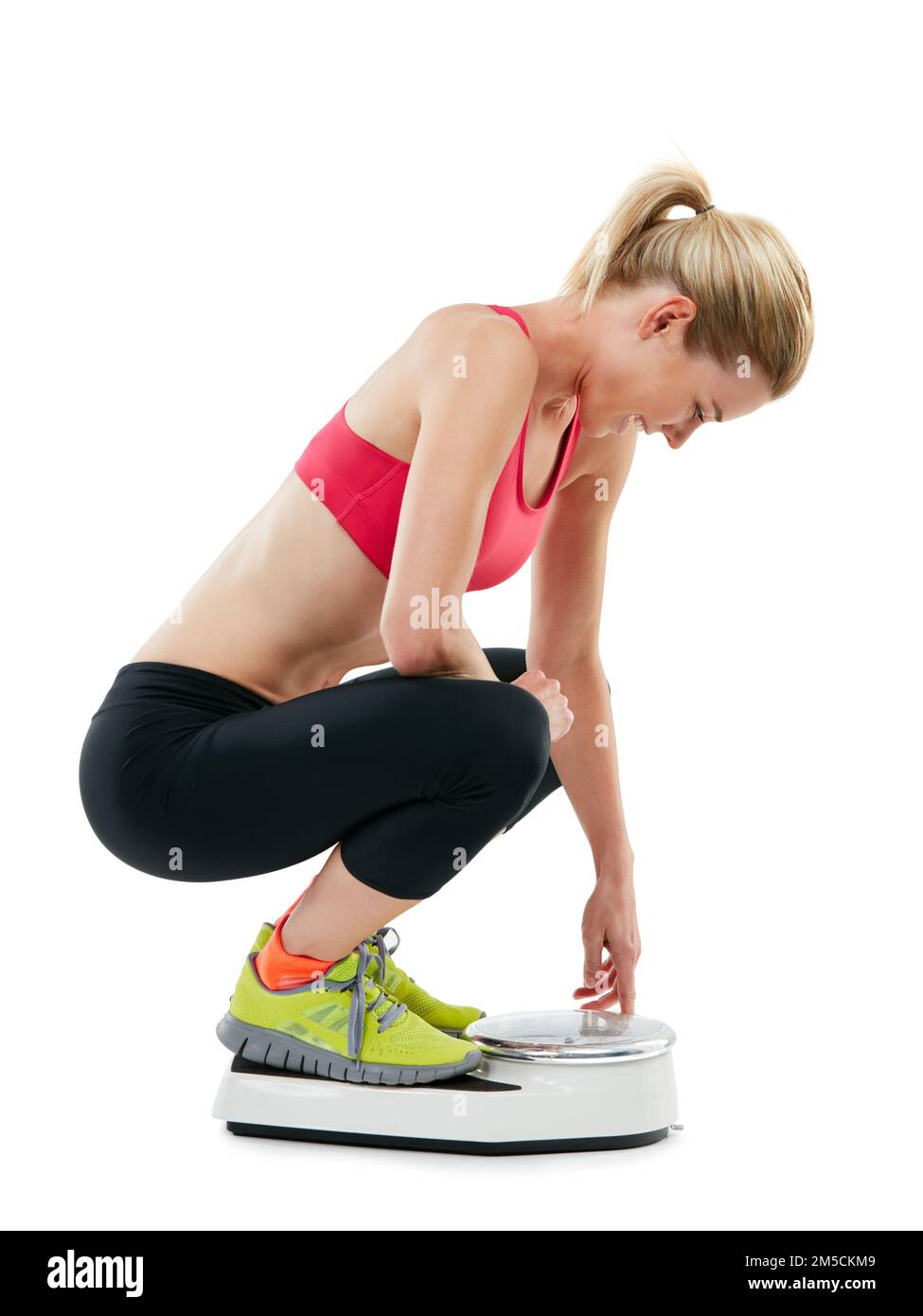 Ausreden sind nutzlos, Ergebnisse unbezahlbar. Studiofoto einer jungen Frau, die sich auf einer Waage wiegt. Stockfoto