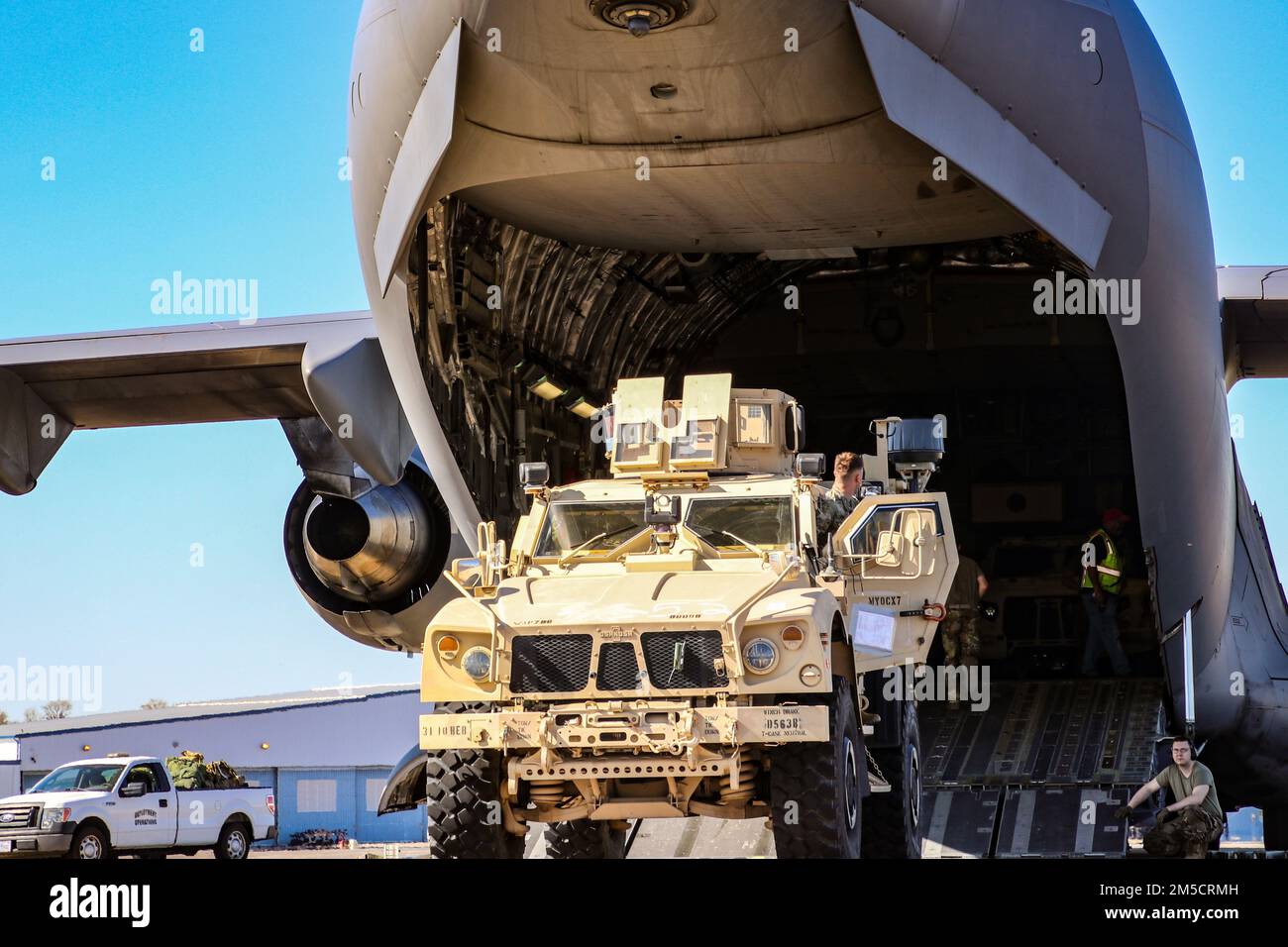 USA Mitglieder des Militärdienstes, die der 3. Infanterie-Division zugeteilt sind, laden ein Joint Light-Tactical-Fahrzeug auf eine Air Force C-17 Globemaster III für einen Einsatz in die USA Einsatzgebiet der Army Europe and Africa, vom Hunter Army Airfield, Georgia, 2. März 2022. Das 1. Panzerbrigade-Kampfteam aus Fort Stewart, 3. ID, wird nach Deutschland reisen, um NATO-Verbündete zu beruhigen, russische Aggressionen abzuwehren und bereit zu sein, eine Reihe anderer Anforderungen in der Region zu unterstützen. Stockfoto