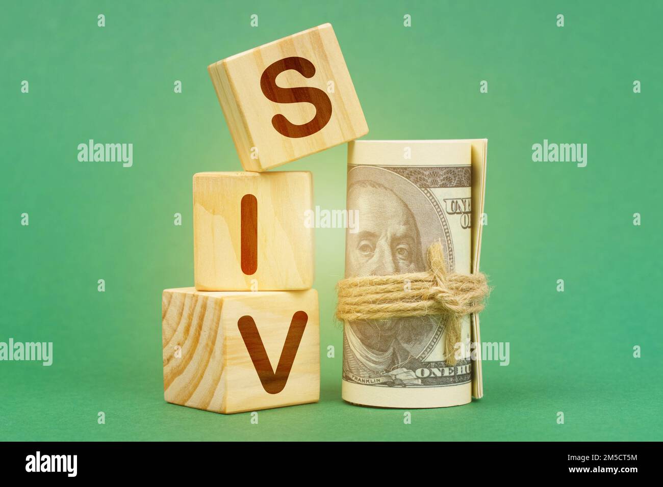 Geschäftskonzept. Auf einer grünen Oberfläche, Dollars und Würfel mit der Inschrift - SIV Stockfoto