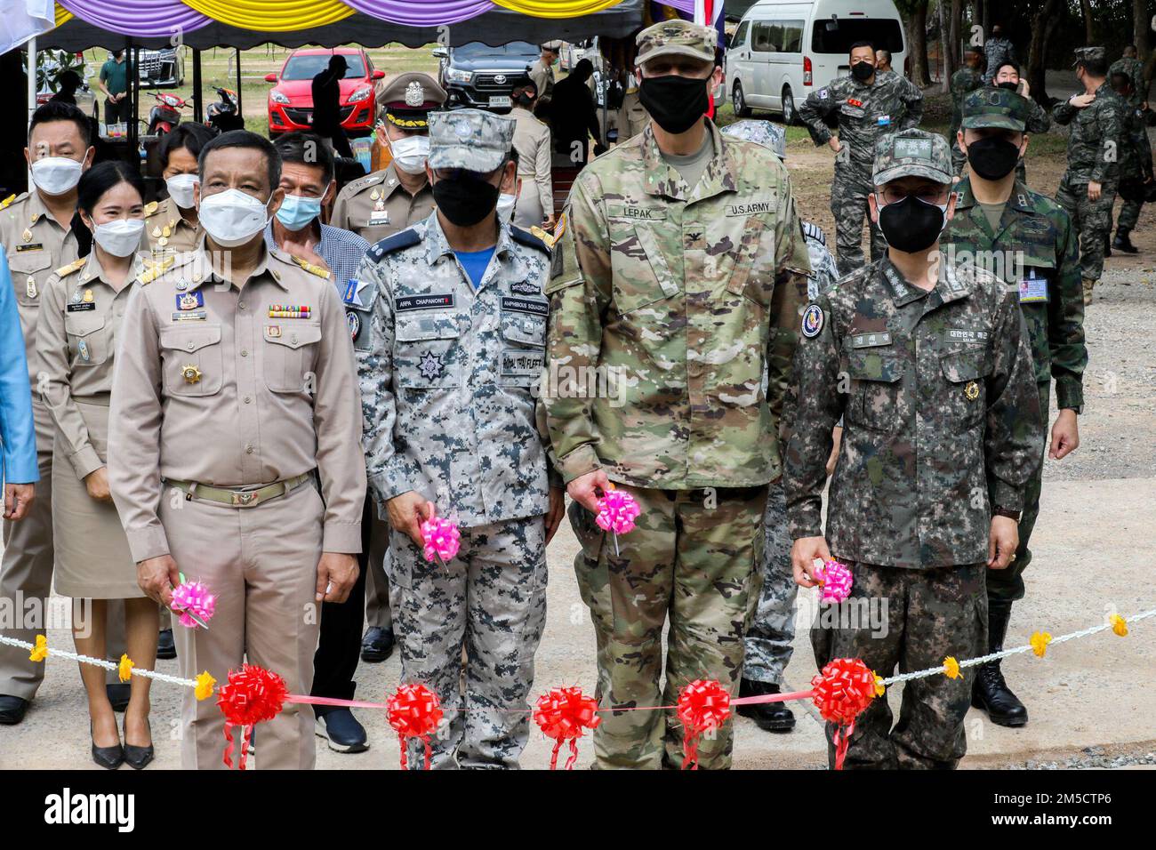 Unterleutnant Pirun Hemarak (links), stellvertretender Gouverneur von Rayong; Oberstleutnant Marty Lepak (rechts vom Zentrum), Direktor für Reserveangelegenheiten der Armee beim I Corps; Und die Führer der kombinierten indo-pazifischen Einheit posieren vor dem Zeremonialband der neu gebauten Schule während der Einweihungszeremonie im Rahmen der Cobra Gold 2022 in Rayong, Provinz Rayong, Königreich Thailand, 2. März 2022. CG 22 ist die 41. Wiederholung der internationalen Ausbildungsübung, die die Bereitschaft unterstützt und die Koordinierung in den Bereichen Bürgeraktion, humanitäre Hilfe und Katastrophenhilfe betont. Vom 22. Februar bis 4. März 2022, Stockfoto
