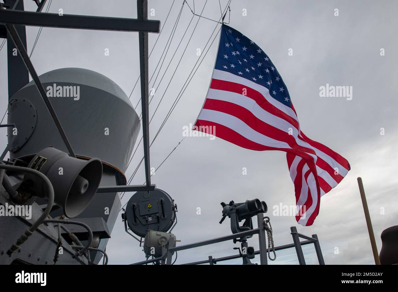 220303-N-KW492-2126 PAZIFIK (3. März 2022) die amerikanische Flagge wird auf dem Mast der Arleigh-Burke-Klasse-Guided-Missile Destroyer USS Milius (DDG 69) gehisst. Milius ist der Destroyer-Staffel (DESRON) 15 zugeteilt und unterstützt derzeit ein freies und offenes Indo-Pacific. CTF 71/DESRON 15 ist die größte vorwärtsstationierte DESRON-Flotte der Marine und die wichtigste Kampftruppe der US-7.-Flotte. Stockfoto