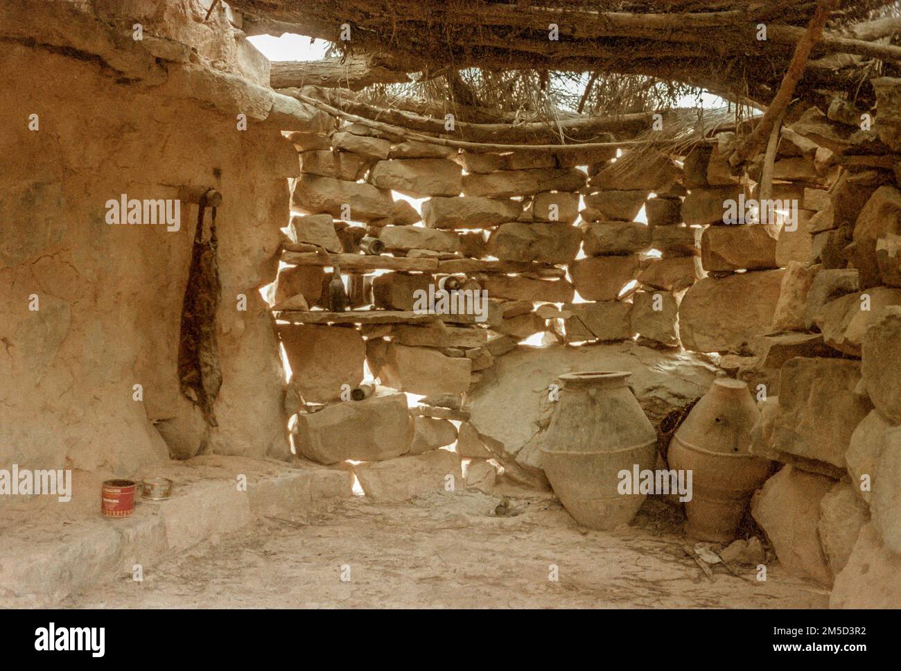 Töpfe aus Steingut befinden sich in den steinernen Dorfhütten, die von Mitgliedern des Shihuh-Stamms verlassen wurden, die mit dem Versprechen von Wasser, Schulen und Kliniken an die Küste gelockt wurden. Musandam-Halbinsel, Oman Stockfoto