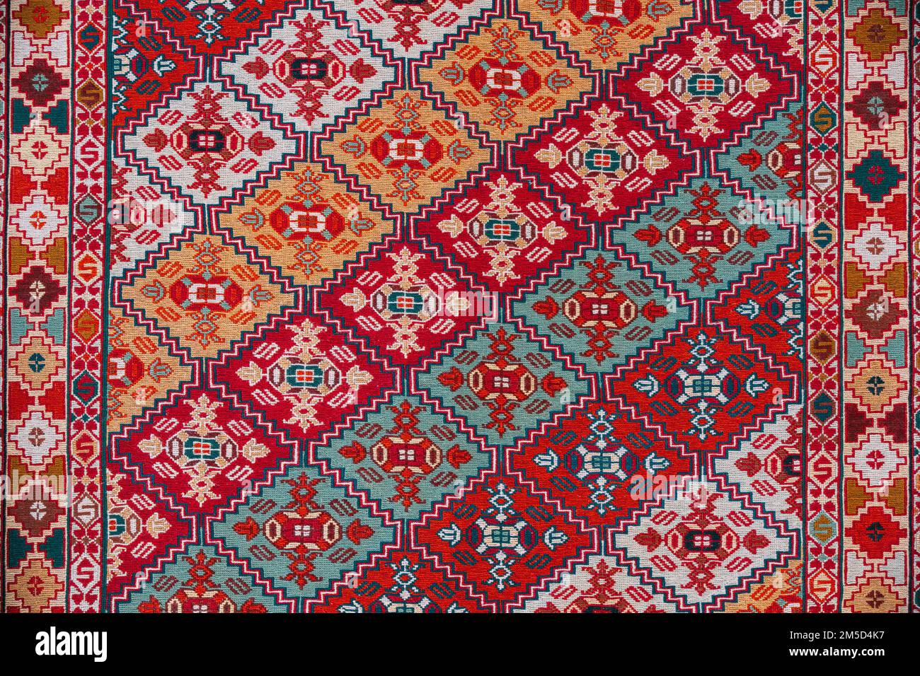 Teppichstruktur, Abstrakte Ornamente. Farbenfroher Teppich Aus Orientalischem Mosaik Mit Traditionellem Ornament. Gemusterter Teppich. Nahaufnahme Des Handgefertigten Gewebten Teppichs Stockfoto