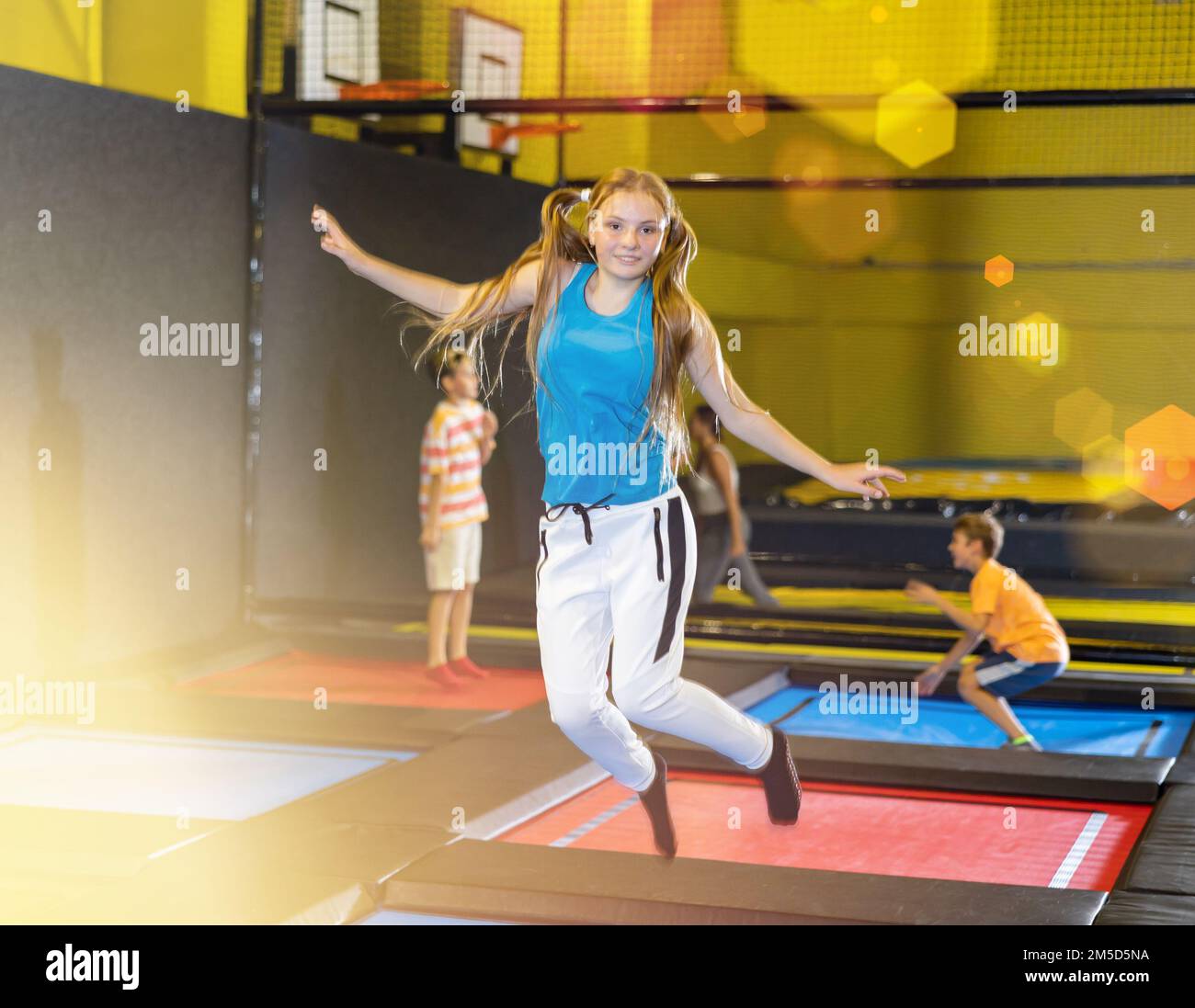 Ein Mädchen, das im Sportzentrum auf dem Trampolinpark springt Stockfoto