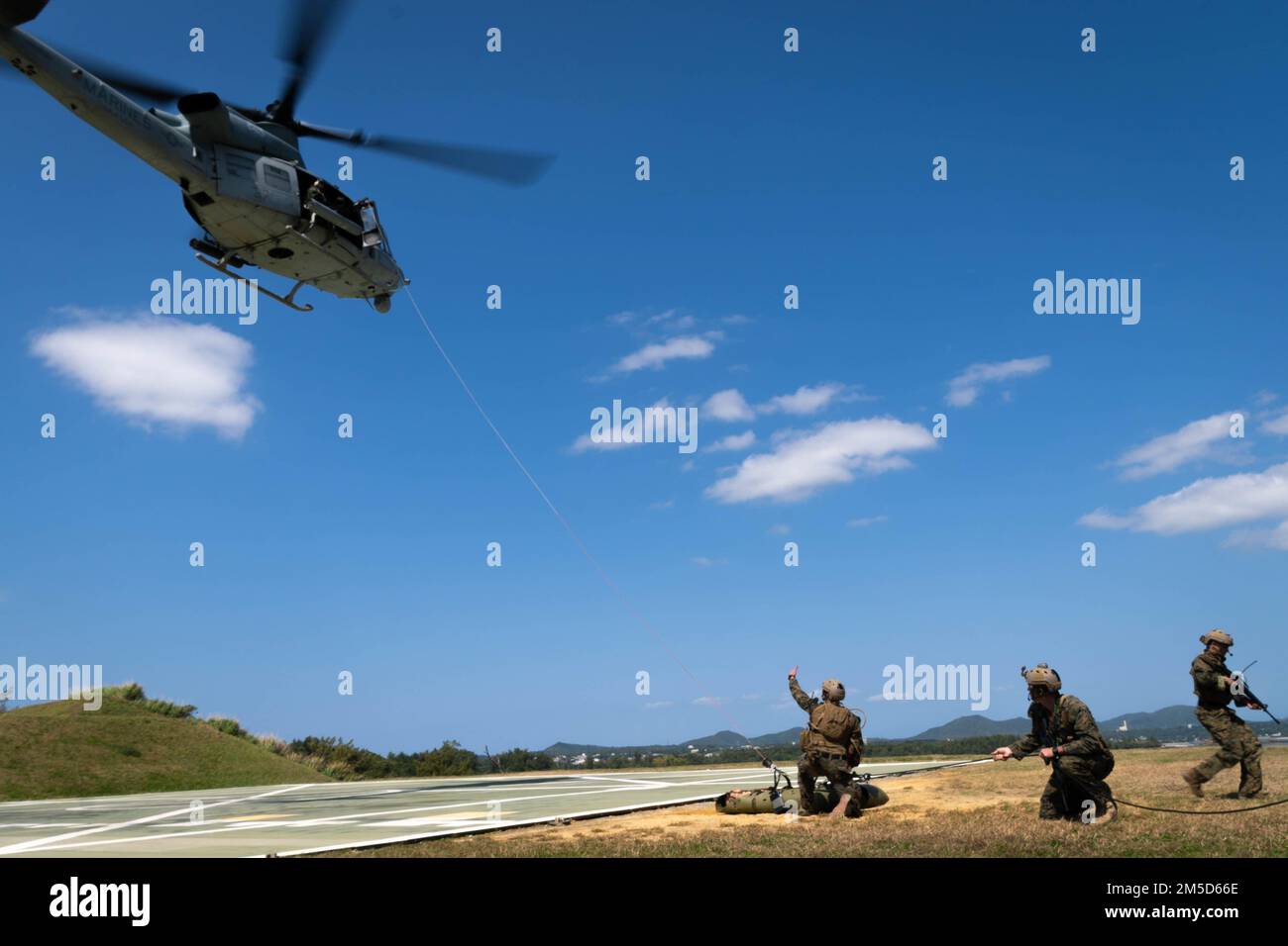 USA Marines mit 3D Aufklärungsbataillon, 3D. Marine Division, laden ein simuliertes Opfer auf ein UH-1Y Gift, das dem Marine Light Attack Helicopter Squadron (HMLA) 369 zugeteilt wurde, während der Evakuierungsübung auf Kin Blue, Okinawa, Japan, 3. März 2022. Die Schulung zur Evakuierung von Unfallopfern wird durchgeführt, um die Leistungsfähigkeit und Reaktionsfähigkeit der Evakuierung von Patienten zu verbessern und sie in eine höhere Versorgungsebene zu transportieren. Stockfoto