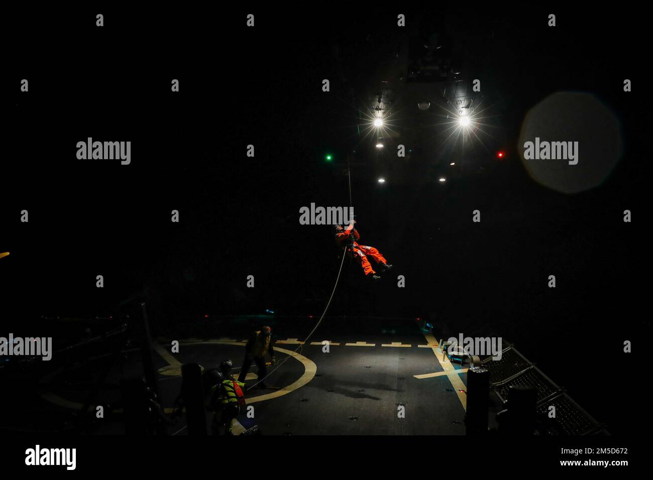 220303-N-EM691-3002 ATLANTISCHER OZEAN (3. März 2022) - Matrosen, die der Arleigh-Burke-Klasse-Guided-Missile Destroyer USS zugewiesen wurden die Sullivans (DDG 68) helfen bei Abendoperationen der Frauen auf dem Cockpit des Schiffes, März 3. Die Sullivans werden in das europäische Operationstheater entsandt und nehmen an einer Reihe von maritimen Aktivitäten zur Unterstützung der USA Teil Sechste Flotte und NATO-Alliierten. Stockfoto
