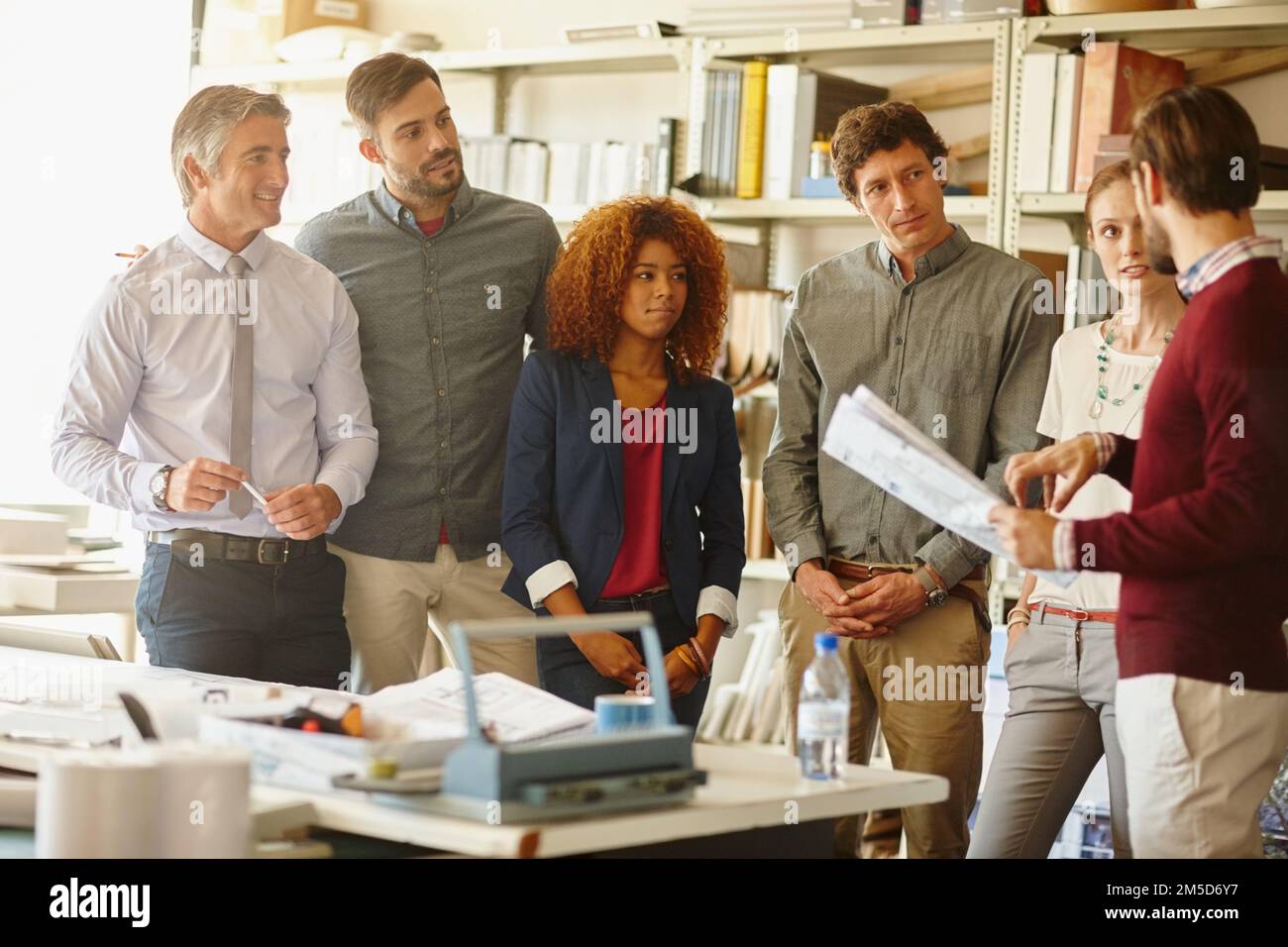 Er bekam ihre volle Aufmerksamkeit. Eine Gruppe von Architekten, die ein Meeting in ihrem Büro abhalten. Stockfoto