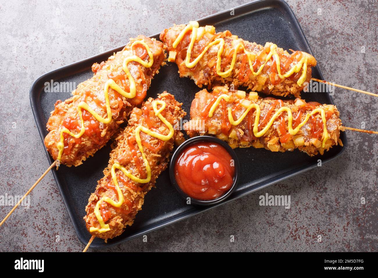 Koreanische Corn Dogs oder koreanische Hot Dogs sind beliebte lokale Street Food-Gerichte, die in der Regel aus Würstchen oder Mozzarella-Käse auf Stäben, frittierte Nahaufnahmen auf dem hergestellt werden Stockfoto