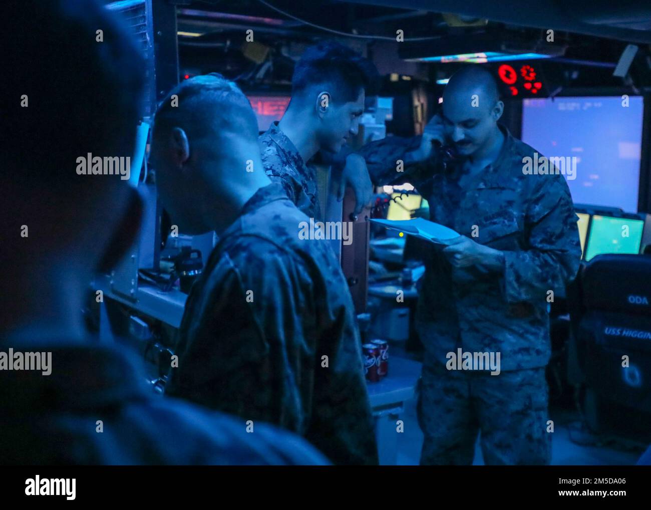 PHILIPPINE SEA (3. März 2022) Marines diskutieren eine Übung im Kampfeinformationszentrum der Arleigh-Burke-Klasse-Raketenzerstörerin USS Higgins (DDG 76). Higgins ist dem Befehlshaber der Task Force (CTF) 71/Destroyer Squadron (DESRON) 15, der größten nach vorn eingesetzten DESRON der Marine und der Hauptstreitkräfte der US-7.-Flotte zugewiesen. Stockfoto