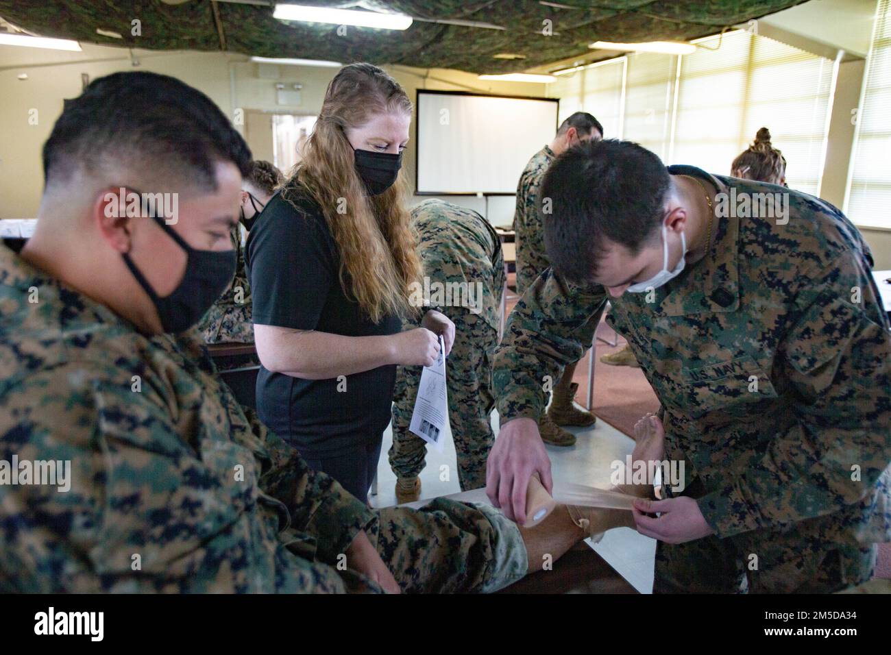 USA Marinekorpsmen der III Marine Expeditionary Force Information Group führen praktische Anwendung während eines von Sportlern durchgeführten Knöchelumhüllungskurses in Camp Hansen, Okinawa, Japan, am 4. März 2022 durch. Sporttrainer unterrichten Marines und Matrosen in Verletzungsvermeidungstechniken und führen ein körperliches Rehabilitationstraining durch. Stockfoto