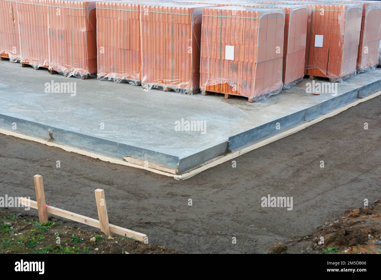 Hohle perforierte Ziegel stehen auf der Bodenplatte für ein eigenes Zuhause Stockfoto