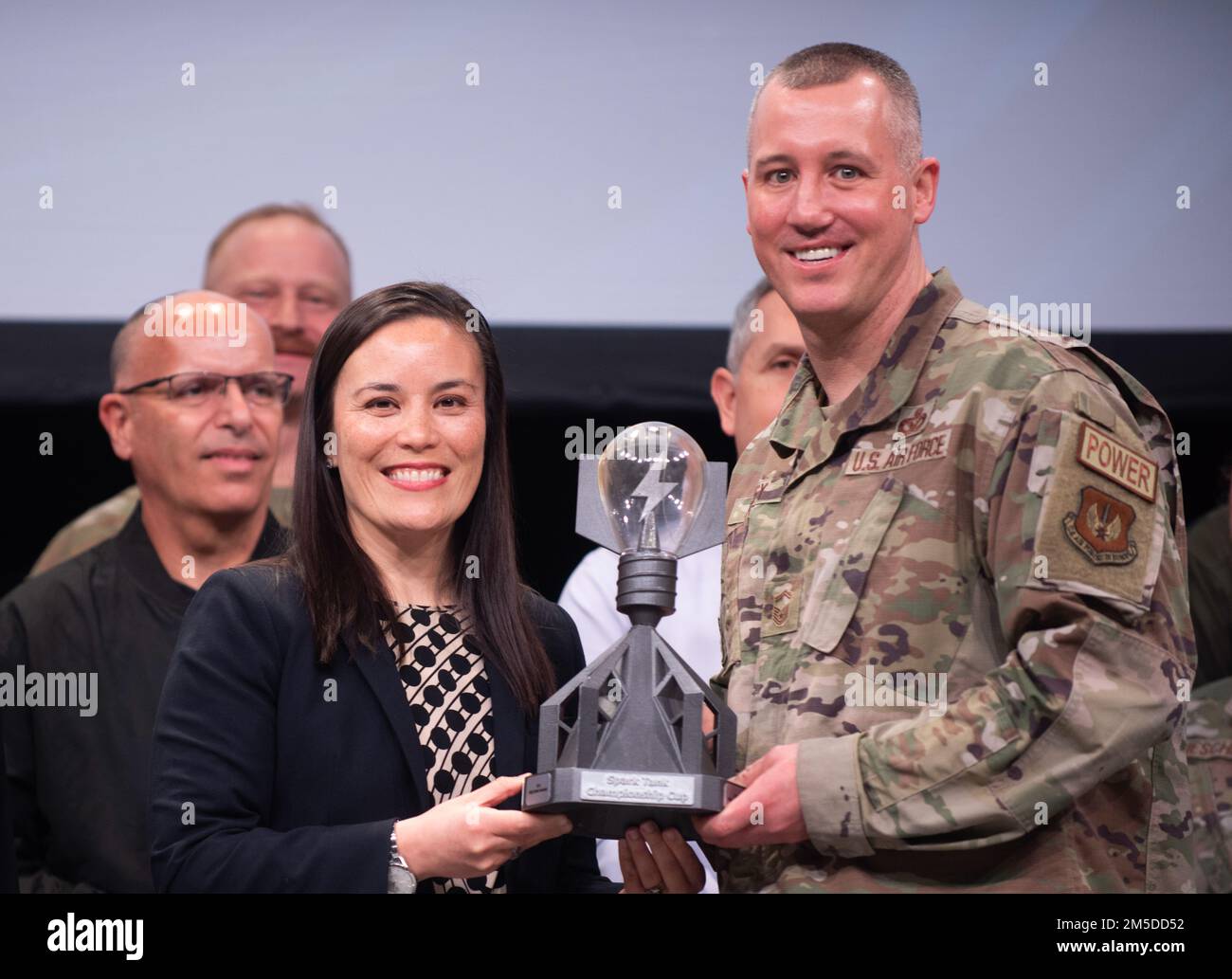 Unterstaatssekretärin der Luftwaffe Gina Ortiz Jones präsentiert Senior Master Sgt. Brent Kenney, 52. Fighter Wing, Luftwaffenstützpunkt Spangdahlem, Deutschland, die Trophäe „The Spark Tank 2022“ auf dem Kriegsbeistandssymposium der Air Force Association in Orlando, Florida, 4. März 2022. Kenneys siegreiche Idee „Project Arcwater“ ist eine einfache, umweltfreundliche und beschleunigte Möglichkeit, Energie zu sparen und Trinkwasser bereitzustellen, indem Solargewebe und umweltfreundliche Wassergewinnung in einem agilen Kampfeinsatz eingesetzt werden. Stockfoto