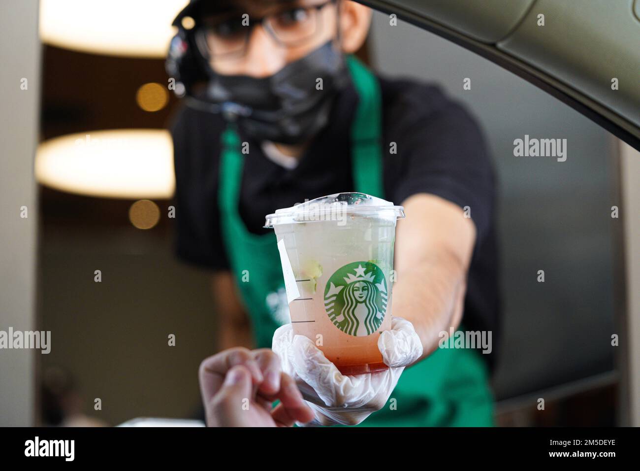 Starbucks Mitarbeiter geben Befehle am Drive-in. Limonade Erdbeere. Stockfoto