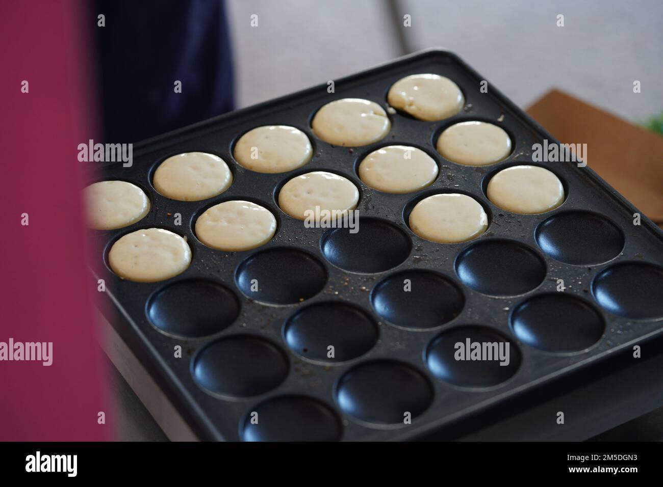 Ich mache morgens Mini-Pfannkuchen auf der Pfannkuchenmaschine. Stockfoto