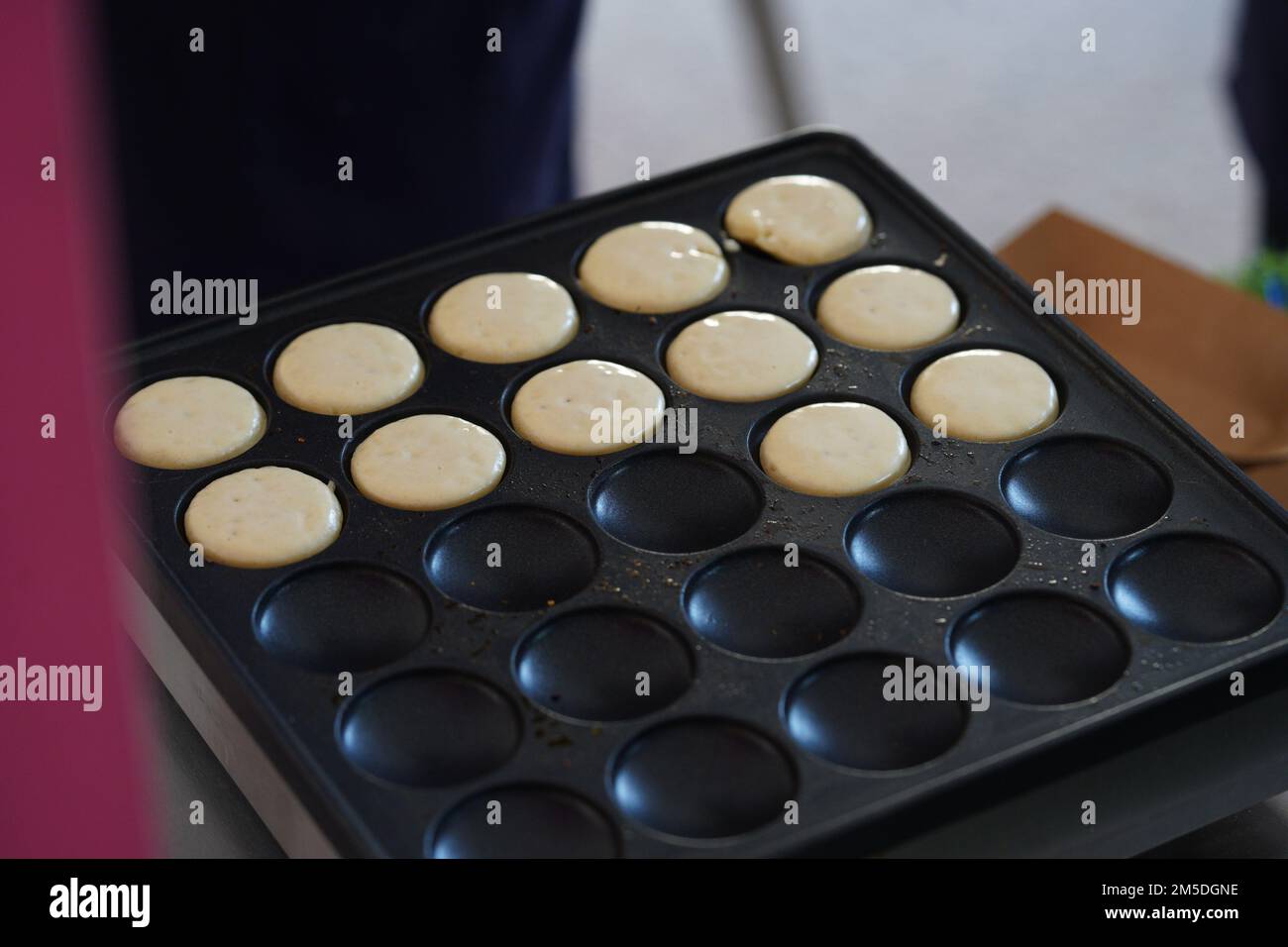 Ich mache morgens Mini-Pfannkuchen auf der Pfannkuchenmaschine. Stockfoto