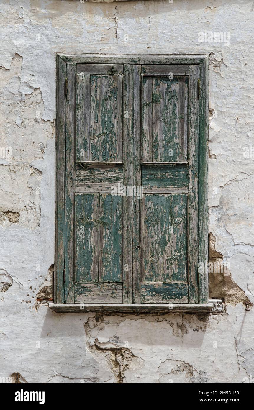 Ein Fenster mit wetterabgenutzten grünen Holzläden in einem alten Gebäude auf der spanischen Insel Menorca Stockfoto