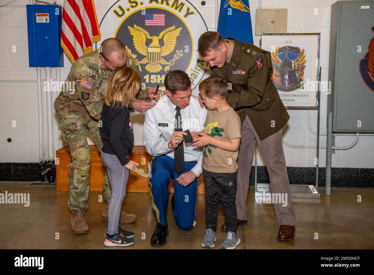 Tyler Callahan, 1. Bataillon, 210. Luftfahrtregiment, kniet nieder, während Oberst Jacob Miller und Kapitän Jacob Terlizzi seinen Kindern bei seiner Beförderung in Fort Eustis, Virginia, am 4. März 2022 helfen. Stockfoto