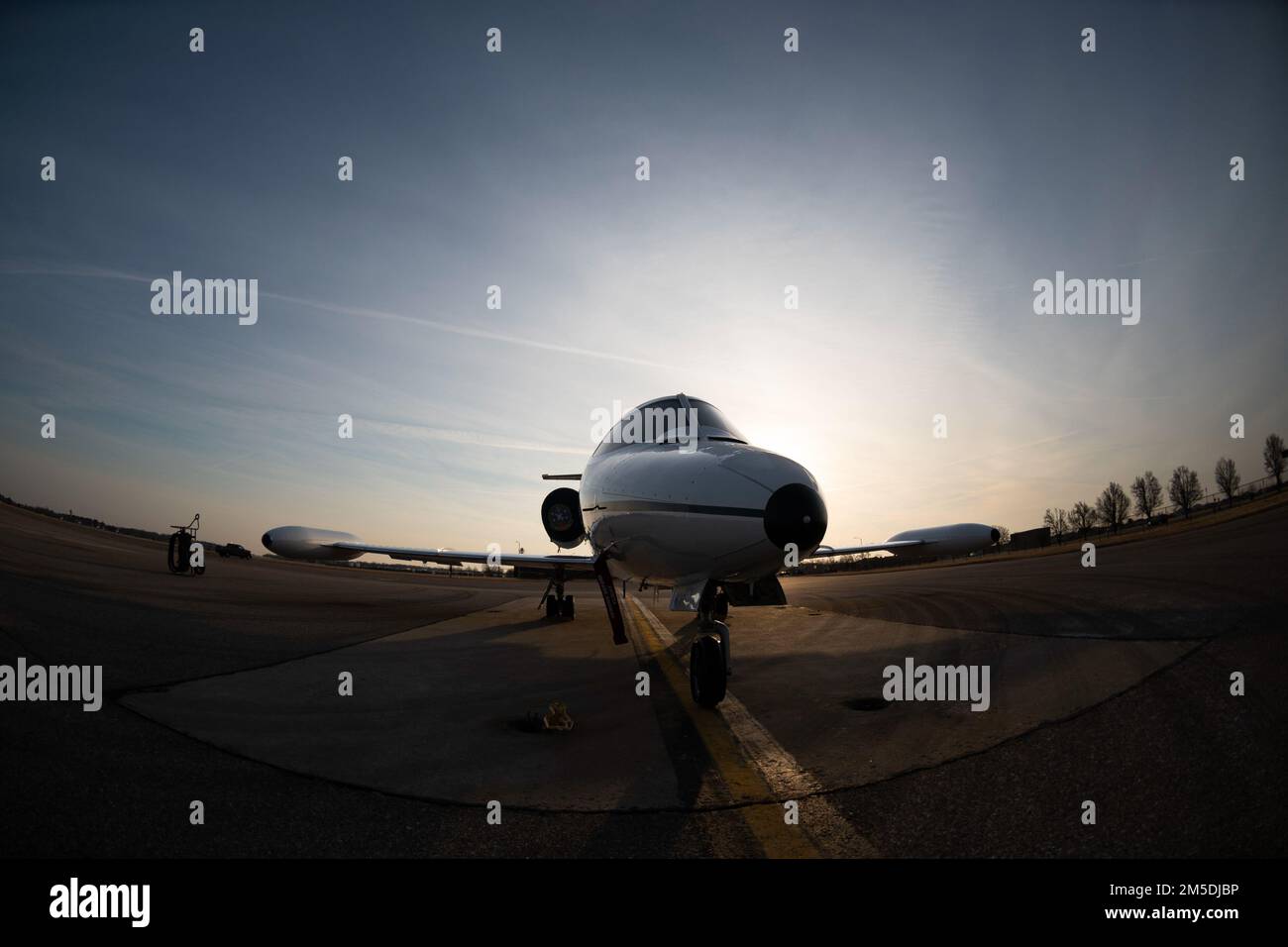 Ein Morgenaufgang hinter einer C-21 auf der Fluglinie am Scott Air Force Base, Illinois, 4. März 2022. Die C-21 ist ein Flugzeug mit zwei Turboventilatoren, das für Fracht-, Passagier- und medizinische Evakuierungs-Luftbrücke verwendet wird. Stockfoto