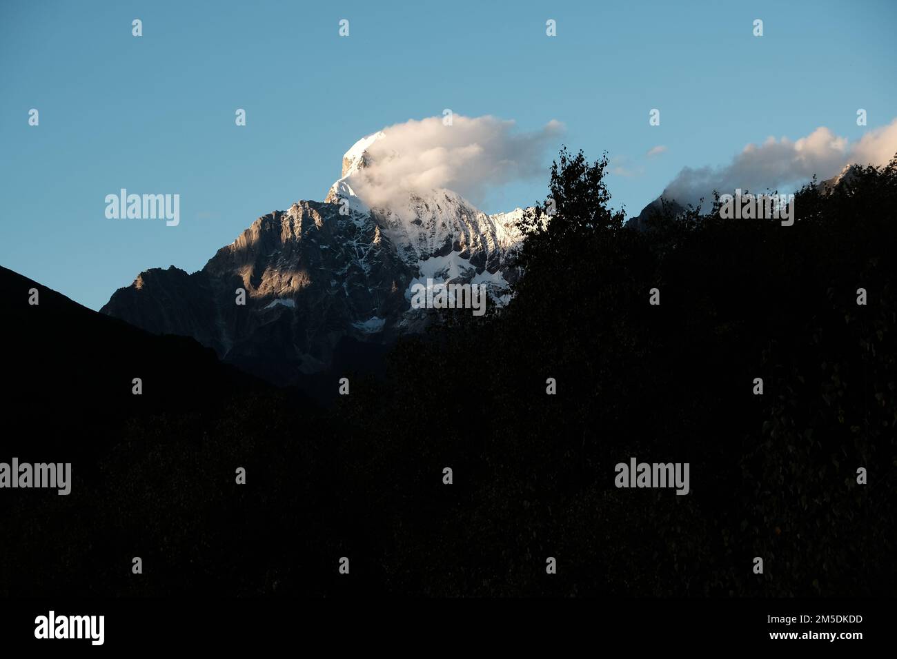 Der Blick auf die schneebedeckten Berge. Panoramablick auf die Berge, blauer Himmel in Sonnenlicht und weiße Dampfwolken. Wunderschöne chinesische Berglandschaft. Stockfoto