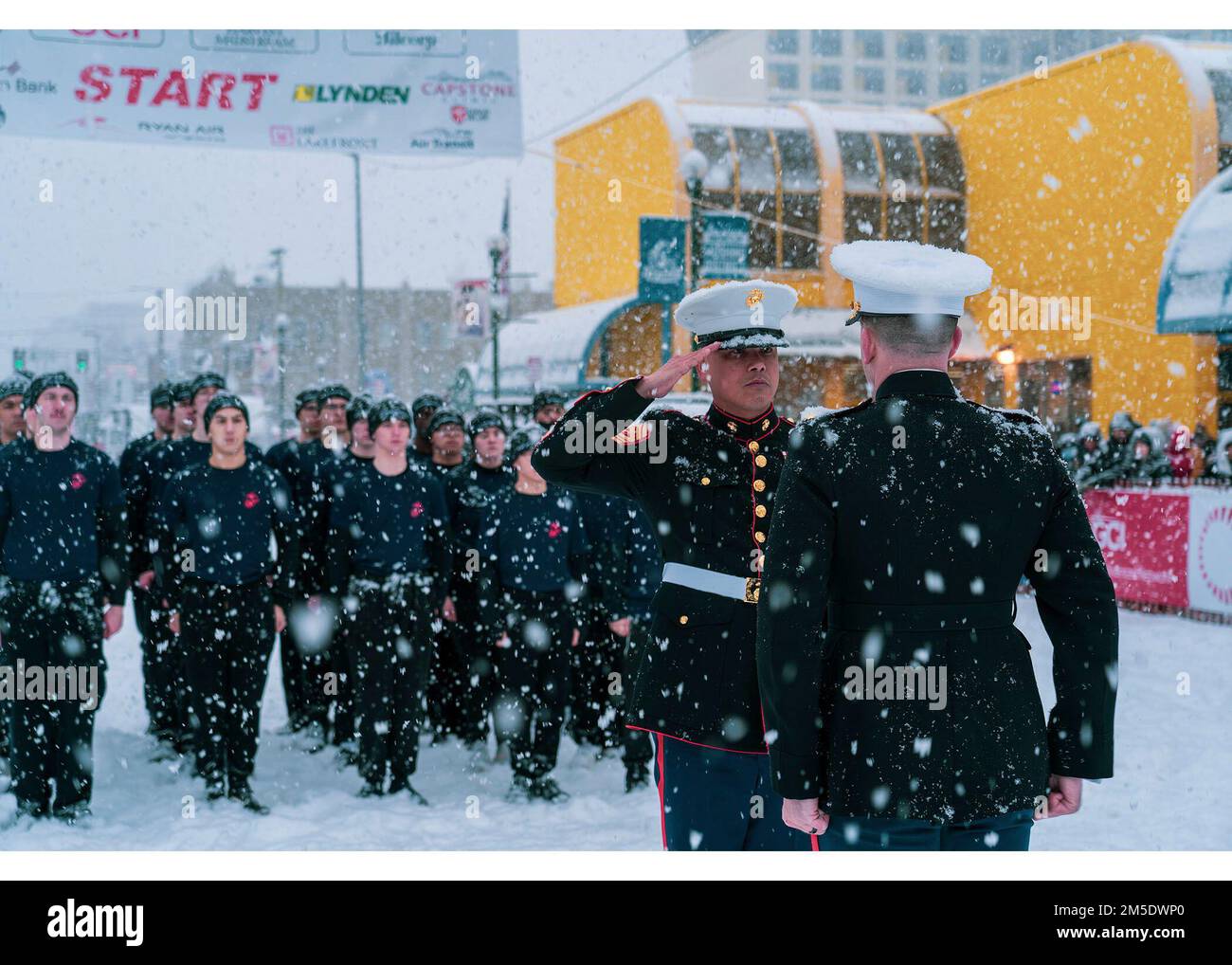 USA Marinekorps-Hauptquartier Abelardo Dominguez, Sergeant Major der Rekrutierungsstation Portland, salutiert den USA Marinekorps-Major Matthew Krempel, der kommandierende Offizier der Recruiting Station Portland, während einer Eid-in-Zeremonie beim Iditarod Trail Schlittenhunderrennen 2022 in Anchorage, Alaska, am 5. März 2022. Die Marines hatten die Gelegenheit, eine Eid-in-Zeremonie unter dem Startbanner durchzuführen und Zuschauer über die Möglichkeiten aufzuklären, die das Marine Corps zu bieten hat. Der Iditarod ist ein jährliches Rennen in Alaska, das sich über 900 km erstreckt, von Anchorage bis Nome. Stockfoto