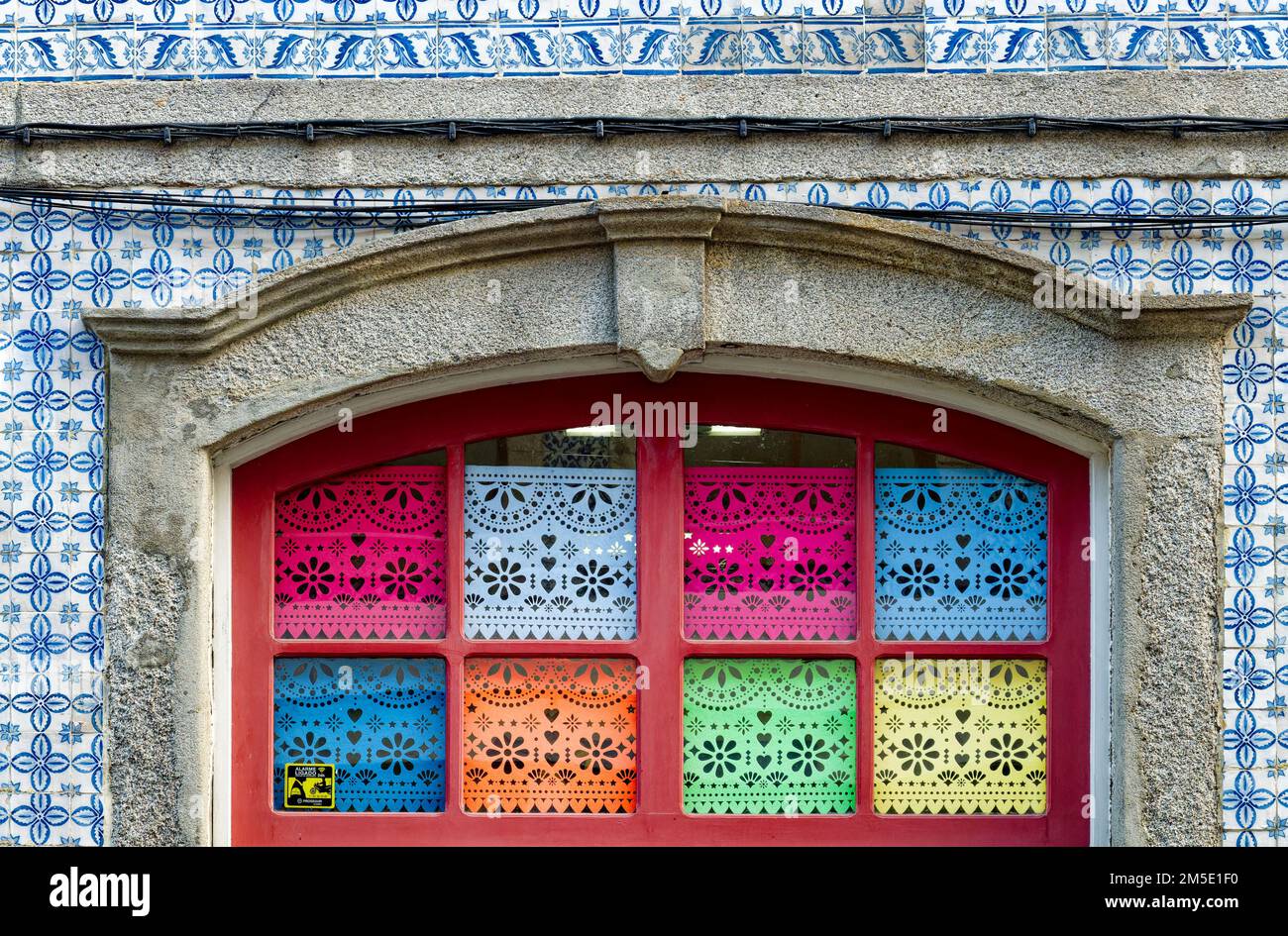 Türbogen umgeben von portugiesischen Azulejos-Fliesen und Fenstern mit Spitzenmuster, Gaia, Porto, Portugal. Stockfoto