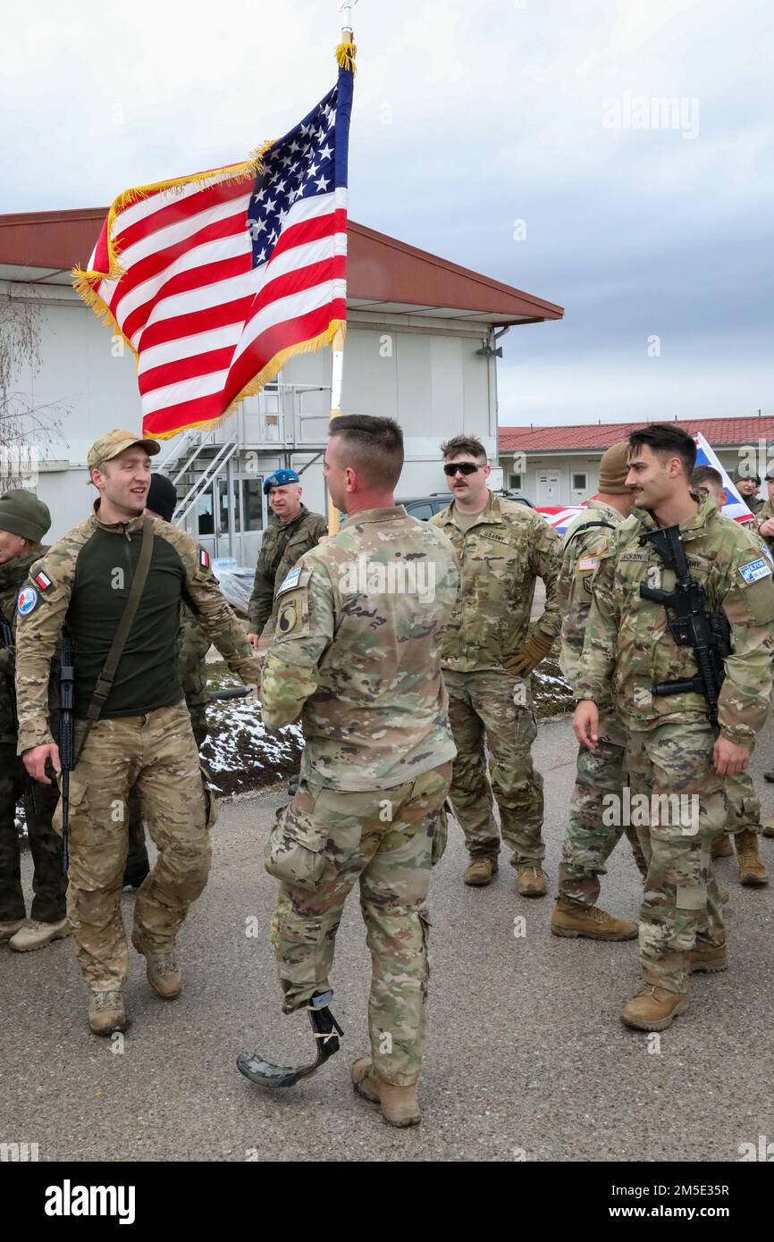 USA Armeekapitän Joshua Pitcher, Einsatzoffizier des 1. Bataillons, 149. Infanterie (Flagge), wird von einem polnischen Soldaten nach dem Polnischen Wolf's Trail Memorial Run in Camp Novo Selo, Kosovo, 6. März 2022 beglückwünscht. Der Polish Wolf’s Trail Memorial Run ist ein 1.963 Meter langer Lauf, der Polens antikommunistische Untergrundbewegung der Nachkriegszeit als „verfluchte Soldaten“ dient. Stockfoto