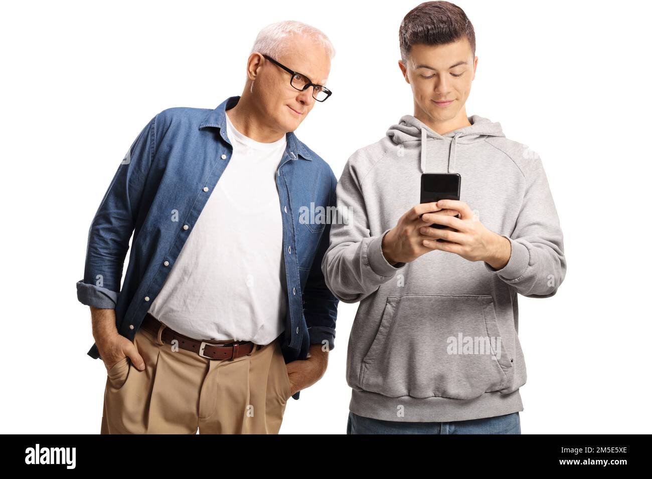 Vater spioniert seinem Sohn nach, während er eine Nachricht auf einem Smartphone tippt, isoliert auf weißem Hintergrund Stockfoto